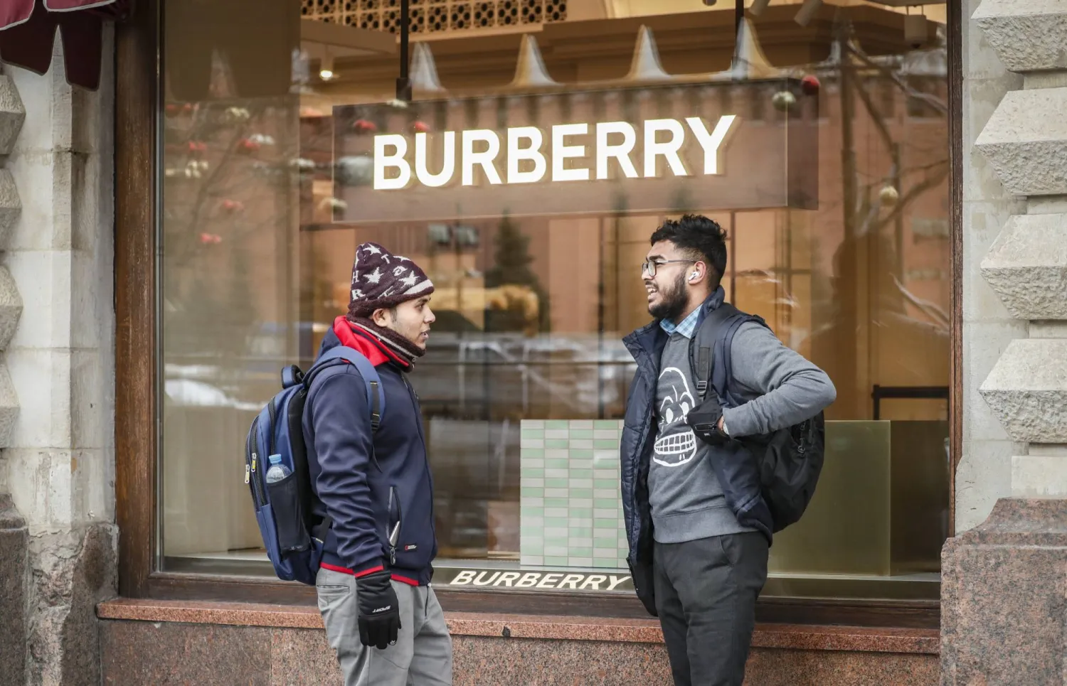 Foreign tourists speak to each other in front of logo of Burberry on a shop-window of closed Burberry retail store in the State Department Store GUM at the Red Square in Moscow, Russia, 13 November 2023. EPA/YURI KOCHETKOV