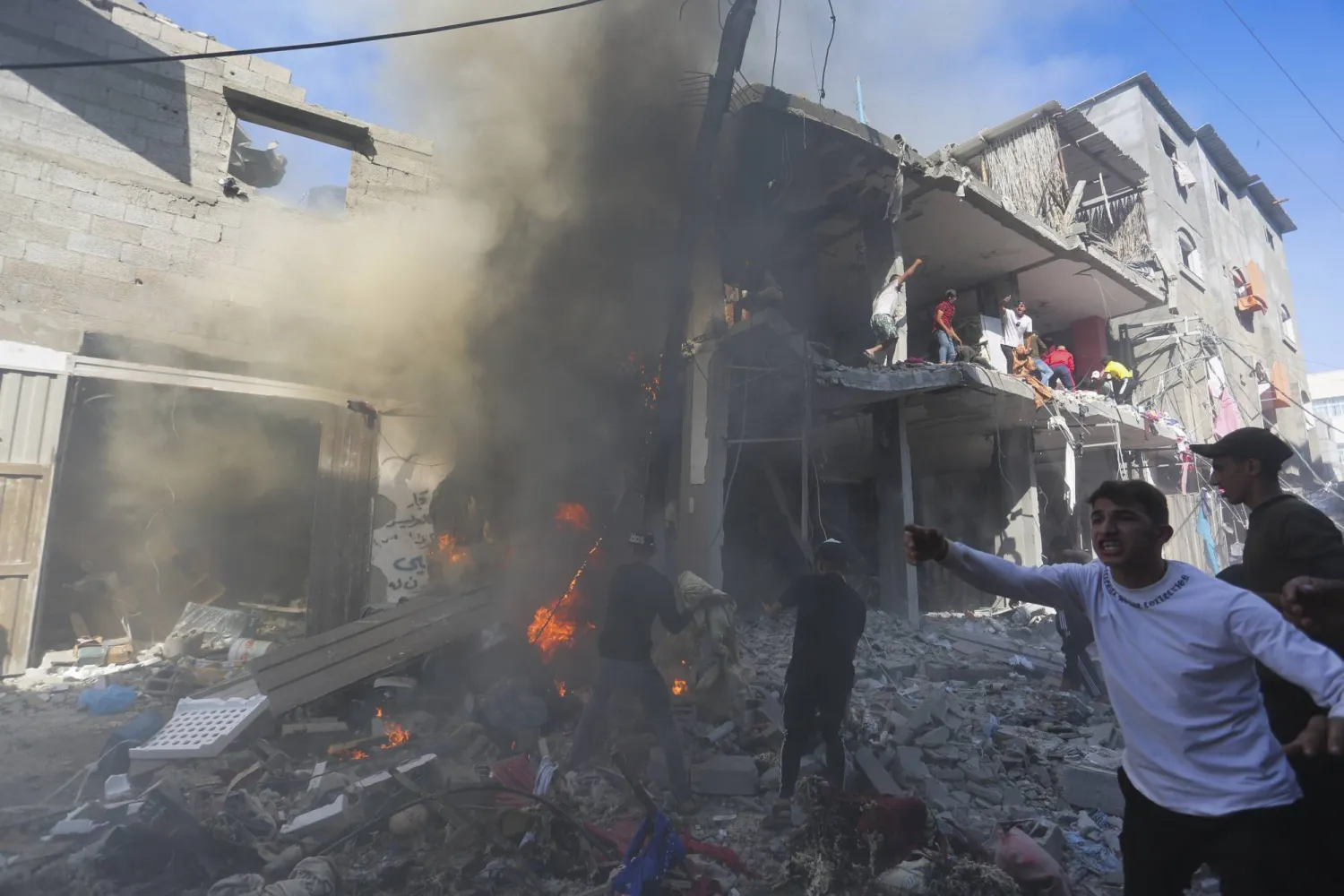 فلسطينيون يبحثون عن ناجين بعد غارة إسرائيلية على رفح في قطاع غزة (أ.ب)