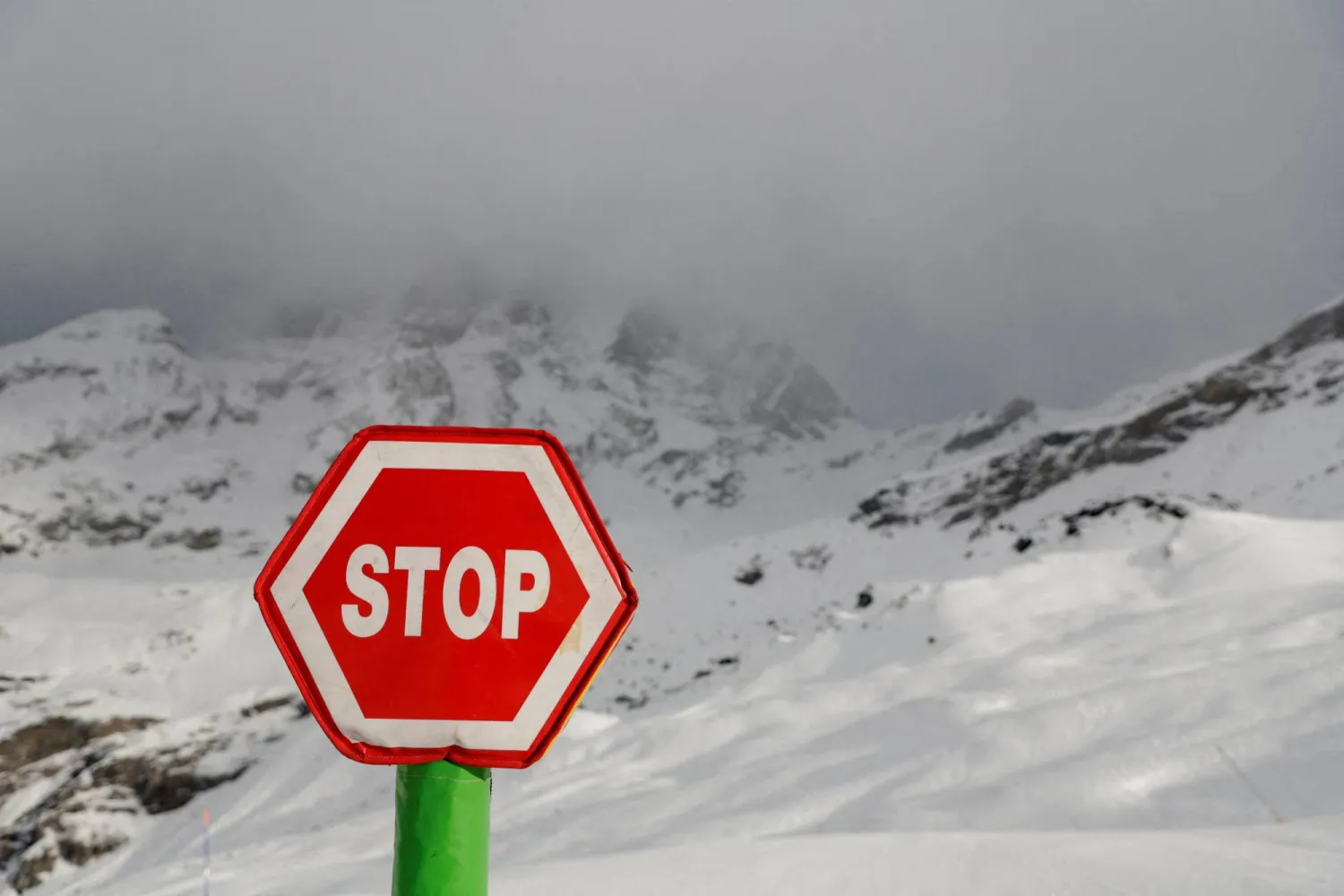 Alpine Skiing - FIS Alpine Ski World Cup - Women's Downhill - Cervinia, Italy - November 18, 2023 A stop sign is pictured infront of Matterhorn mountain as the race is cancelled REUTERS/Leonhard Foeger