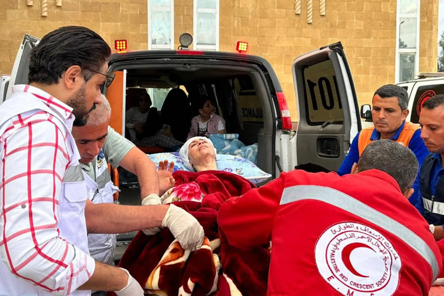 مسعفون ينقلون جرحى فلسطينيين عند وصولهم من غزة إلى الجانب المصري من معبر رفح الحدودي الأحد  (أ.ف.ب)