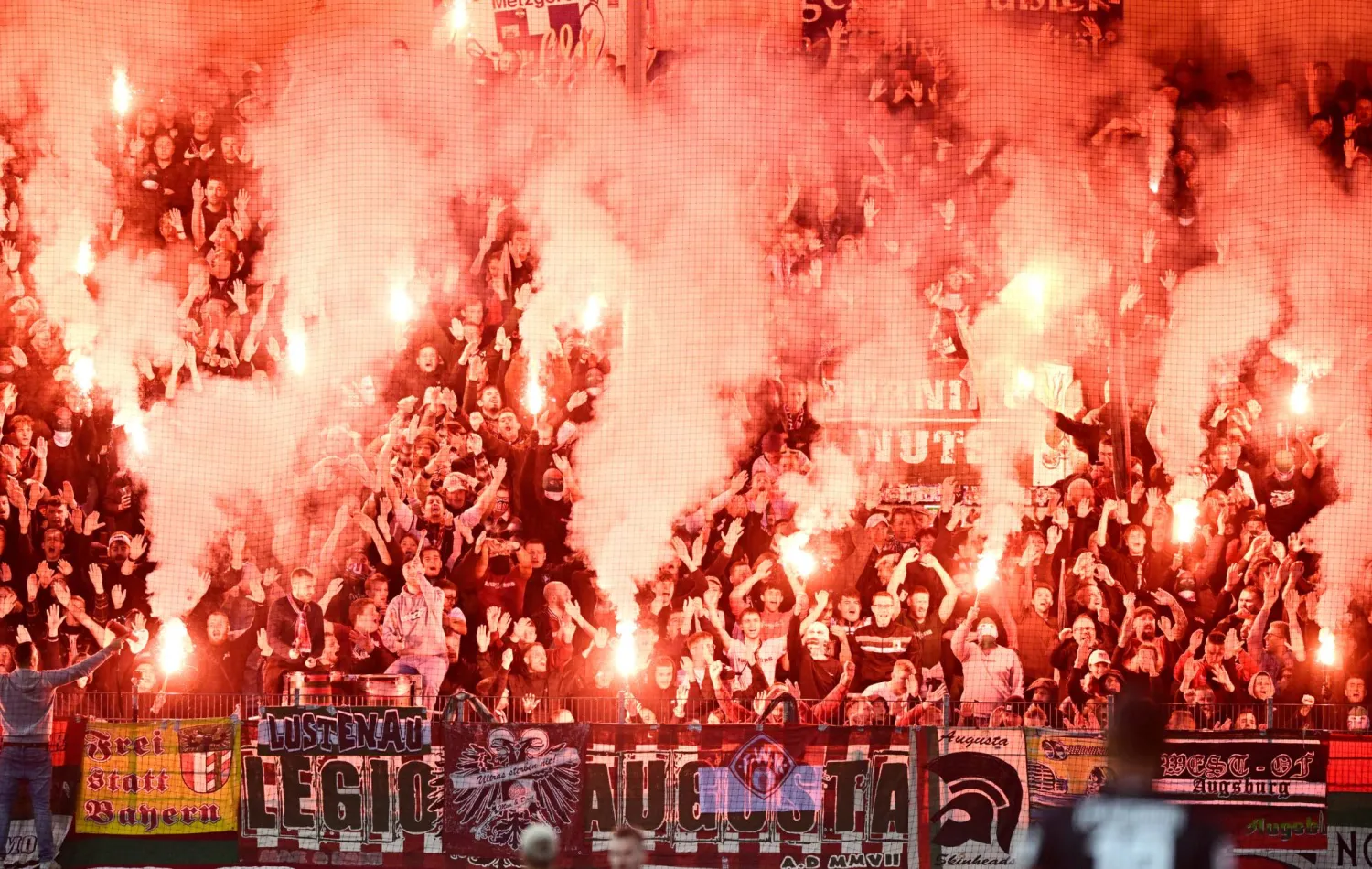 مشجعو أوغسبورغ يطلقون الألعاب النارية خلال مباراة فريقهم أمام هوفنهايم بـ«البوندسليغا» (د.ب.أ)