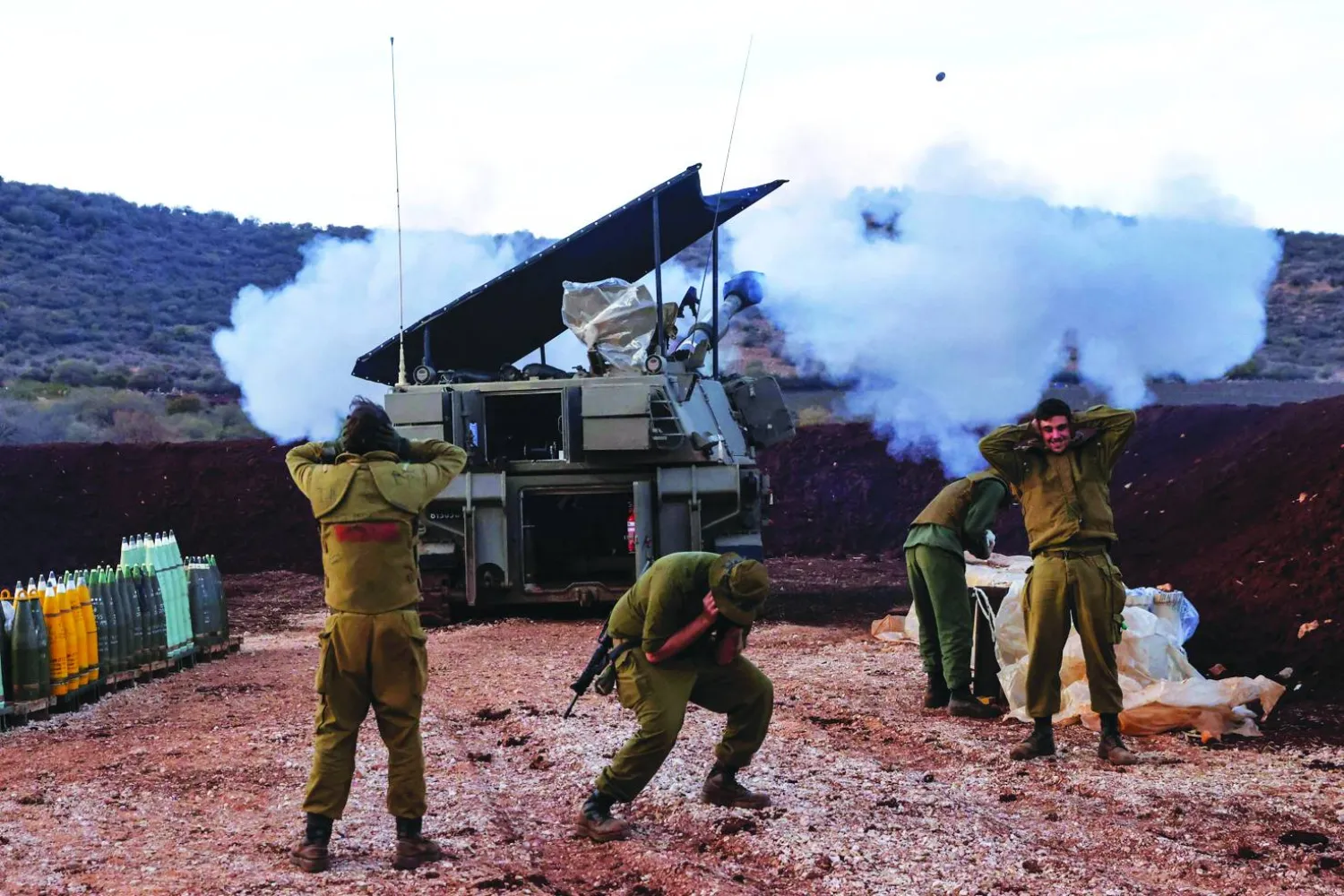 
جنود إسرائيليون في منطقة الجليل يطلقون قذائف مدافعهم باتجاه الأراضي اللبنانية أمس (أ.ف.ب)