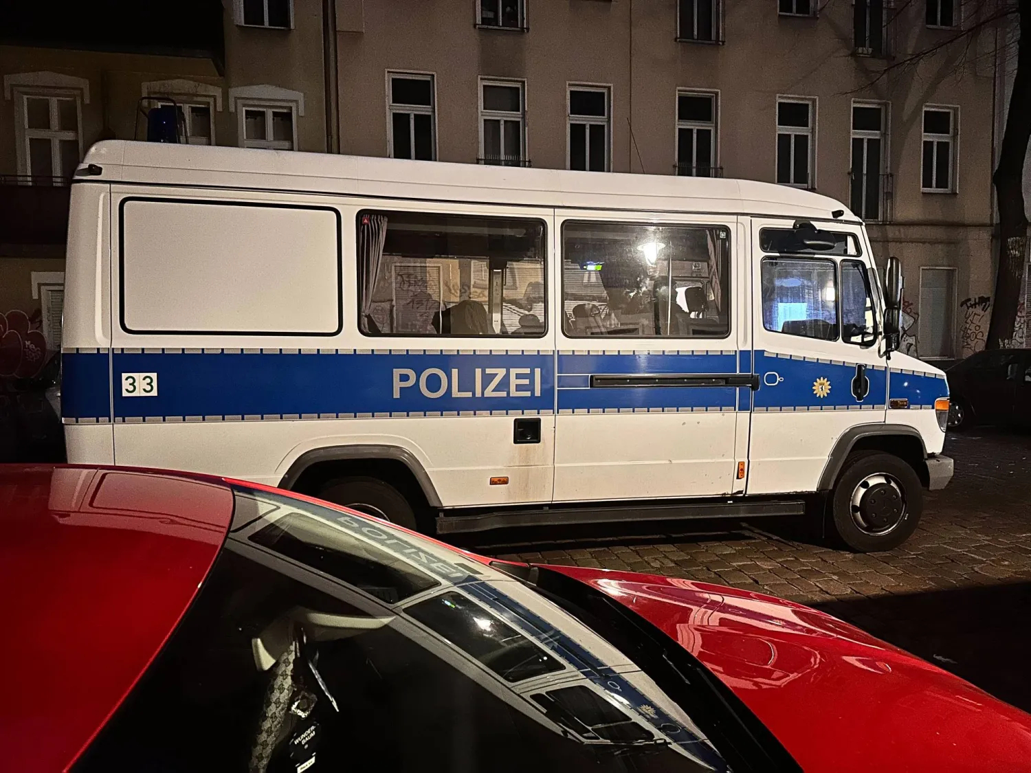 23 November 2023, Berlin: A police vehicle stands on the street during a raid in Berlin-Friedrichshain. Photo: Paul Zinken/dpa