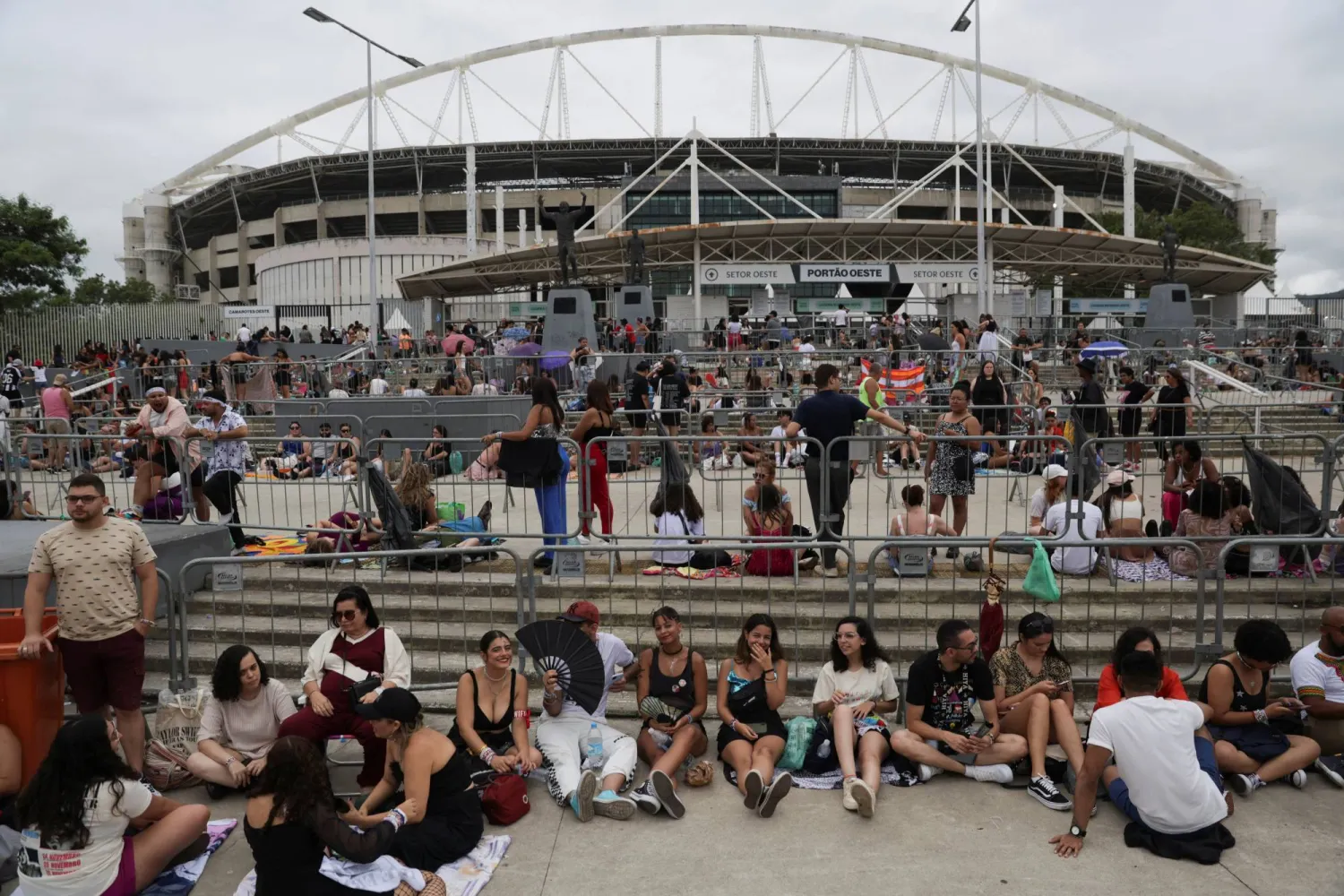 معجبون ينتظرون خارج ملعب نيلتون سانتوس لحضور حفل المغنية تايلور سويفت بعد وفاة أحد المعجبين بسبب الحرارة خلال حفل اليوم الأول في ريو دي جانيرو - البرازيل 20 نوفمبر 2023 (رويترز)