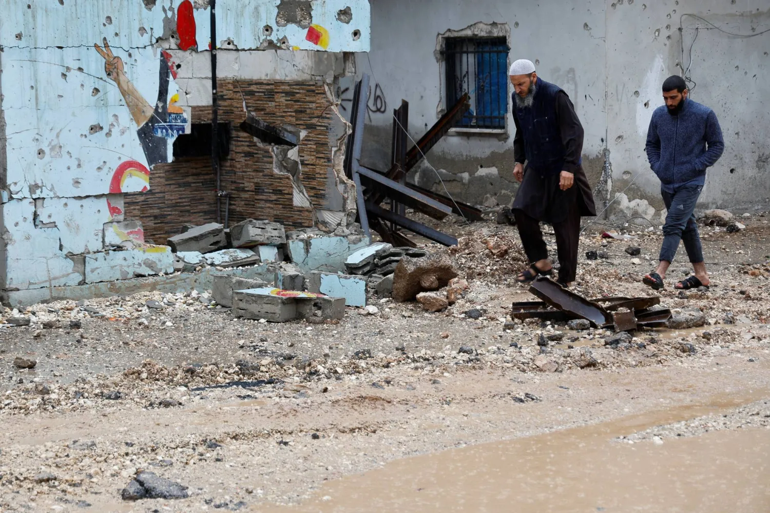 Palestinians walk during rainfall, after Israeli forces raided Jenin refugee camp in the Israeli-occupied West Bank November 19, 2023. REUTERS/Raneen Sawafta