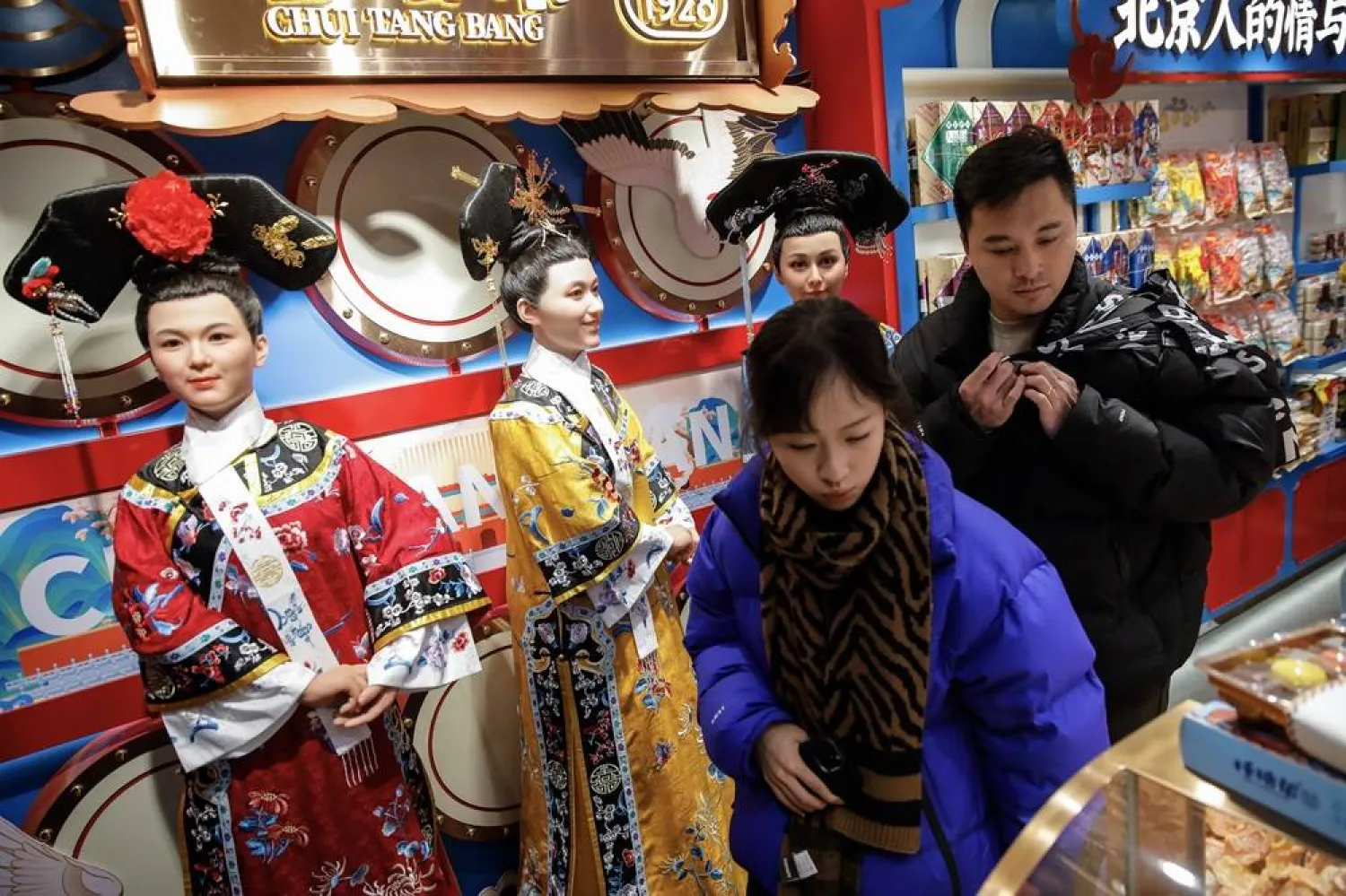 Tourists browse inside a souvenir shop at the Nanluoguxiang tourism area in Beijing, China, 25 November 2023. (EPA)