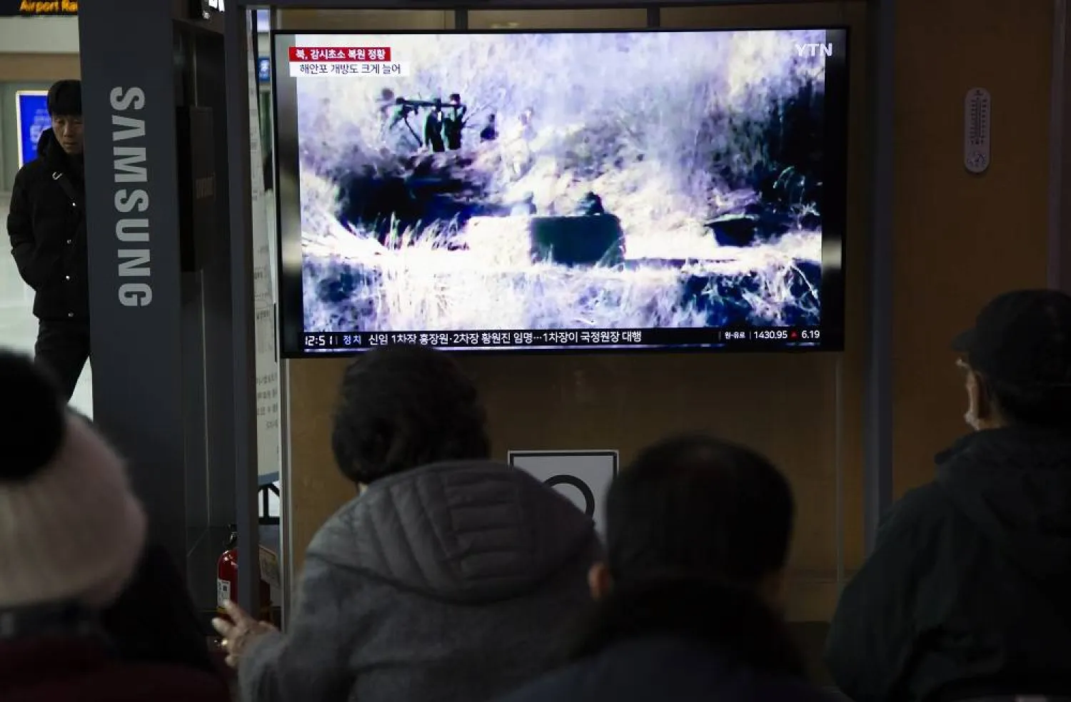 People watch a TV monitor displaying daily news at a station in Seoul, South Korea, 27 November 2023. (EPA)