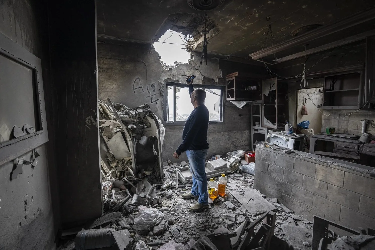 Lübnanlı bir vatandaş İsrail bombardımanına maruz kalan güney bölgesinde yer alan Kafr Kila kasabasındaki evinde meydana gelen hasarı inceliyor. (AP)