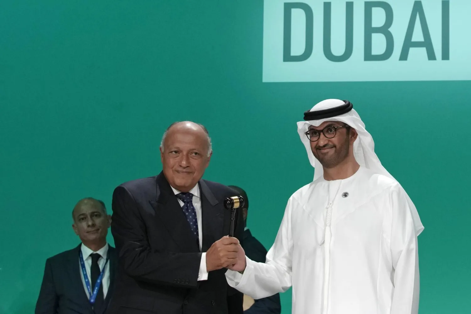 وزير الخارجية المصري سامح شكري يسلم رئاسة المؤتمر إلى وزير الصناعة الإماراتي سلطان الجابر (أ.ب)