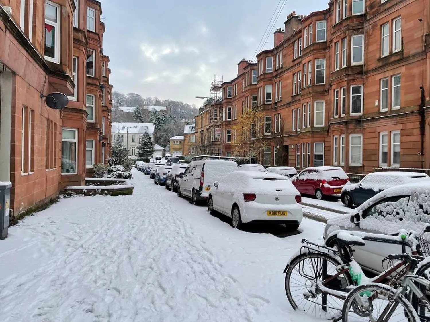 02 December 2023, United Kingdom, Glasgow: Cars are covered with snow in a street in Glasgow. (dpa)