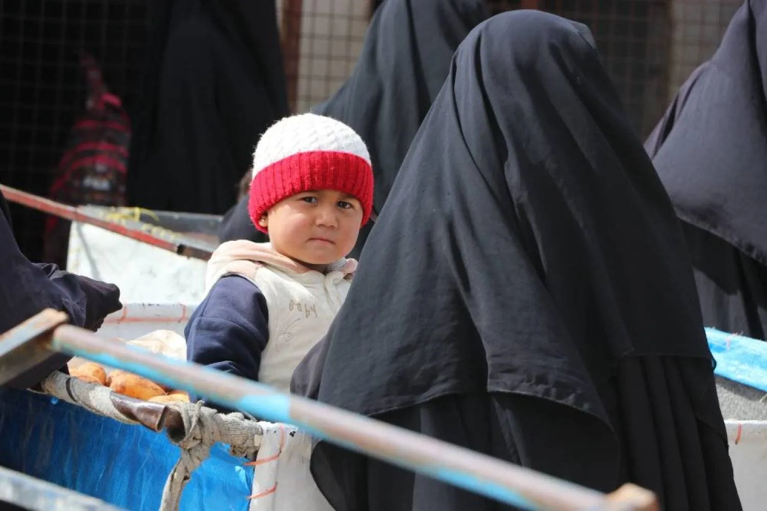 سيدة سبق أن انضمت لـ«داعش» تحمل طفلها في مخيم «الهول» (أرشيف - الشرق الأوسط)