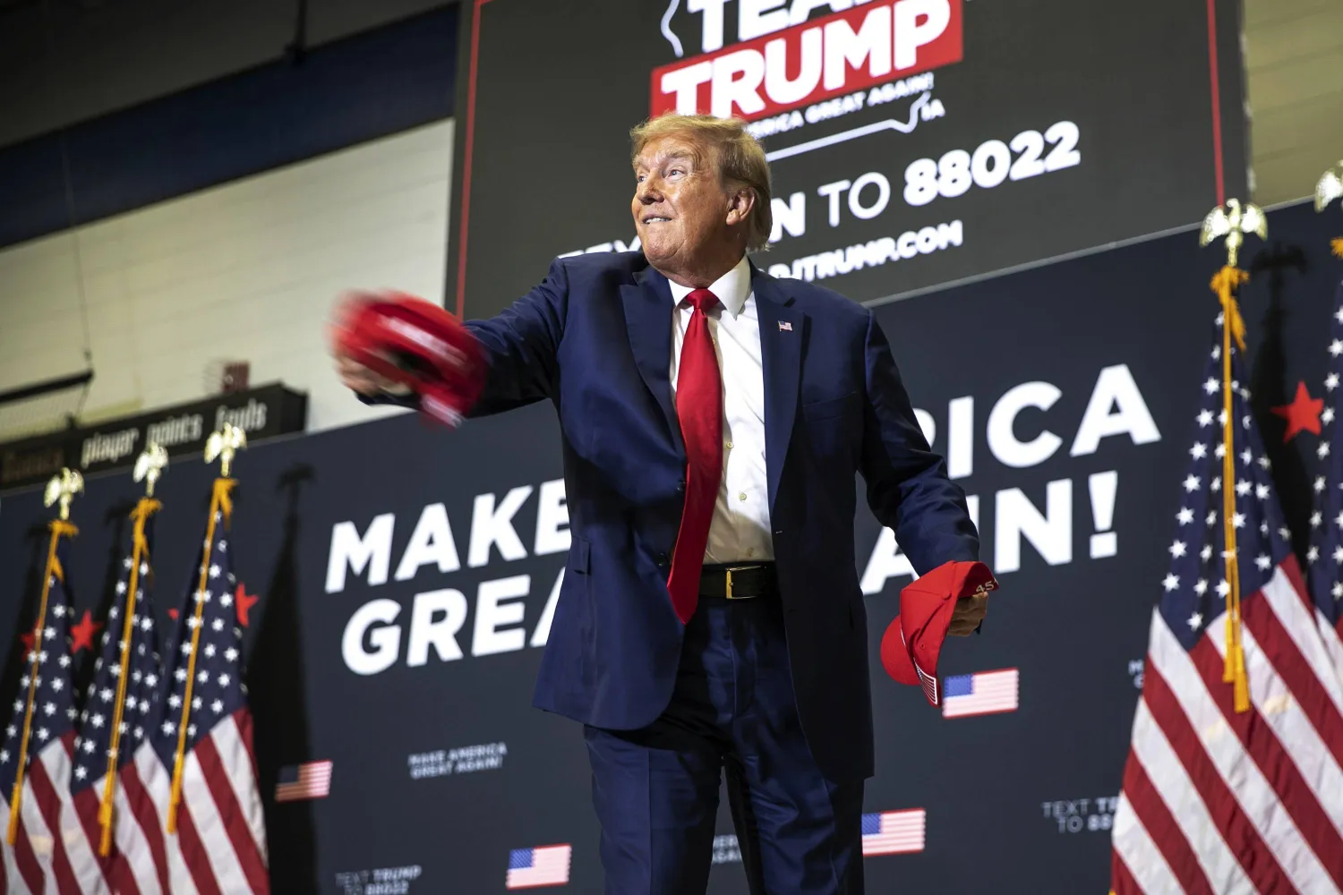 ترمب يرمي قبعات أنصاره خلال اجنماع في أيوا في 2 ديسمبر الحالي (أ. ب)