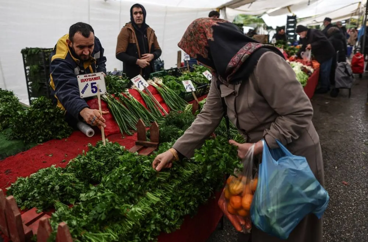 A woman shops at a street market in Istanbul, Türkiye, 04 December 2023. (EPA)