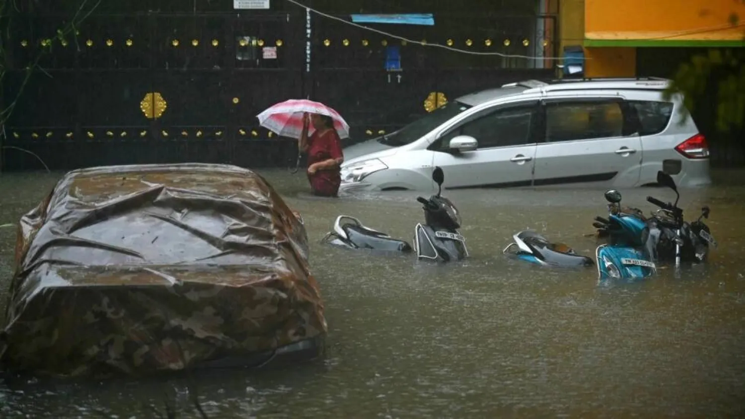 A resident wades through a flooded street after heavy rains in Chennai on December 4. R. Satish BABU / AFP
