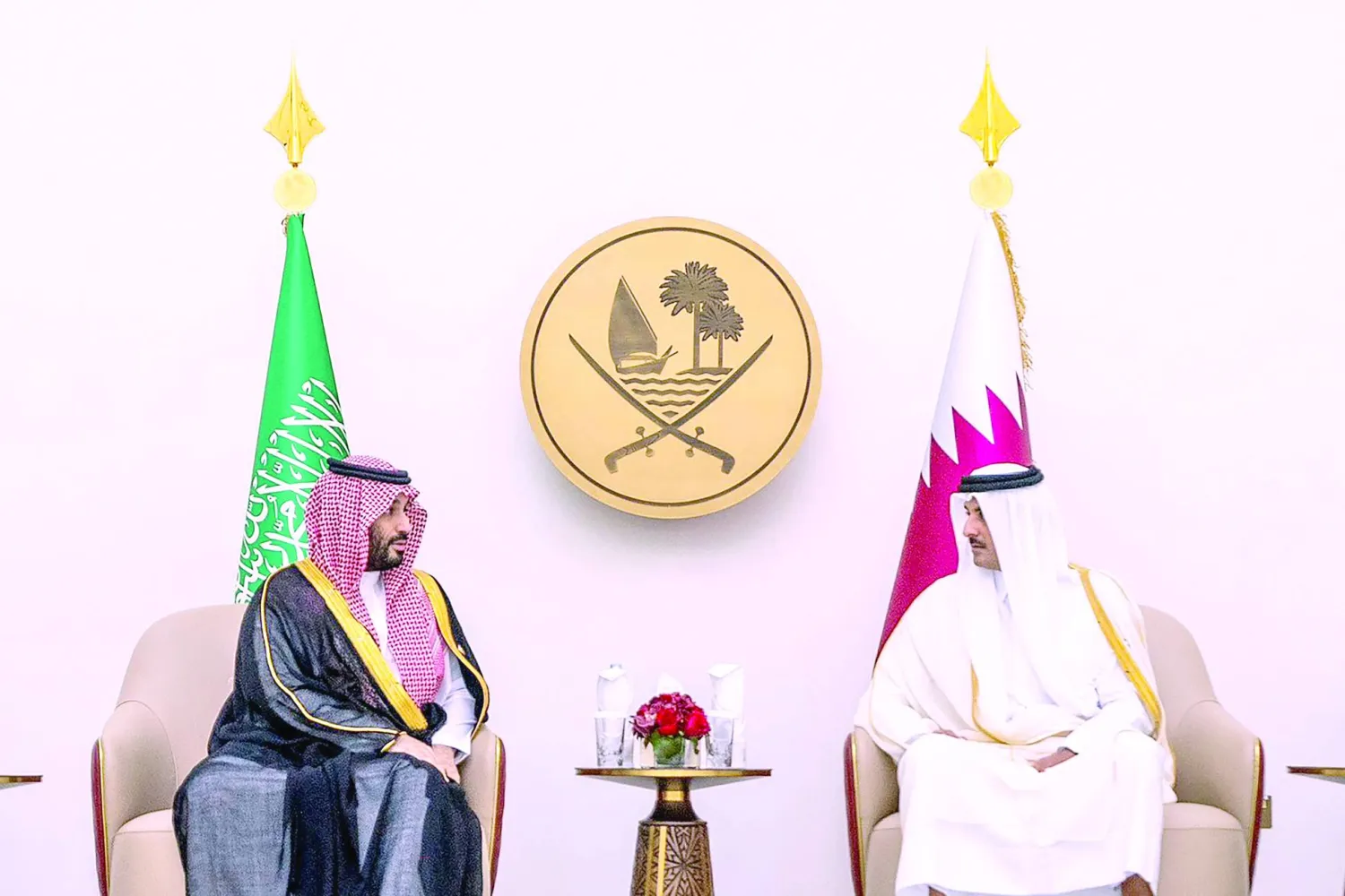 
الأمير محمد بن سلمان والشيخ تميم خلال اجتماعهما على هامش القمة الخليجية أمس (أ.ف.ب)