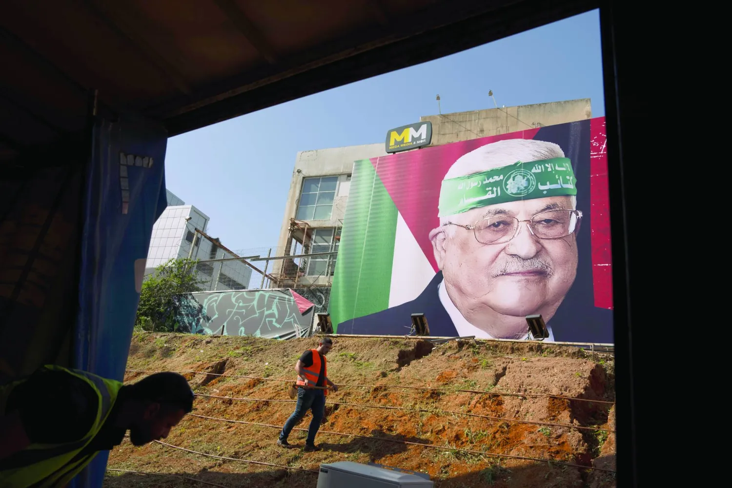 دعاية إسرائيلية في تل أبيب تضع عصبة «حماس» على جبين الرئيس الفلسطيني محمود عباس 23 نوفمبر (أ.ب)