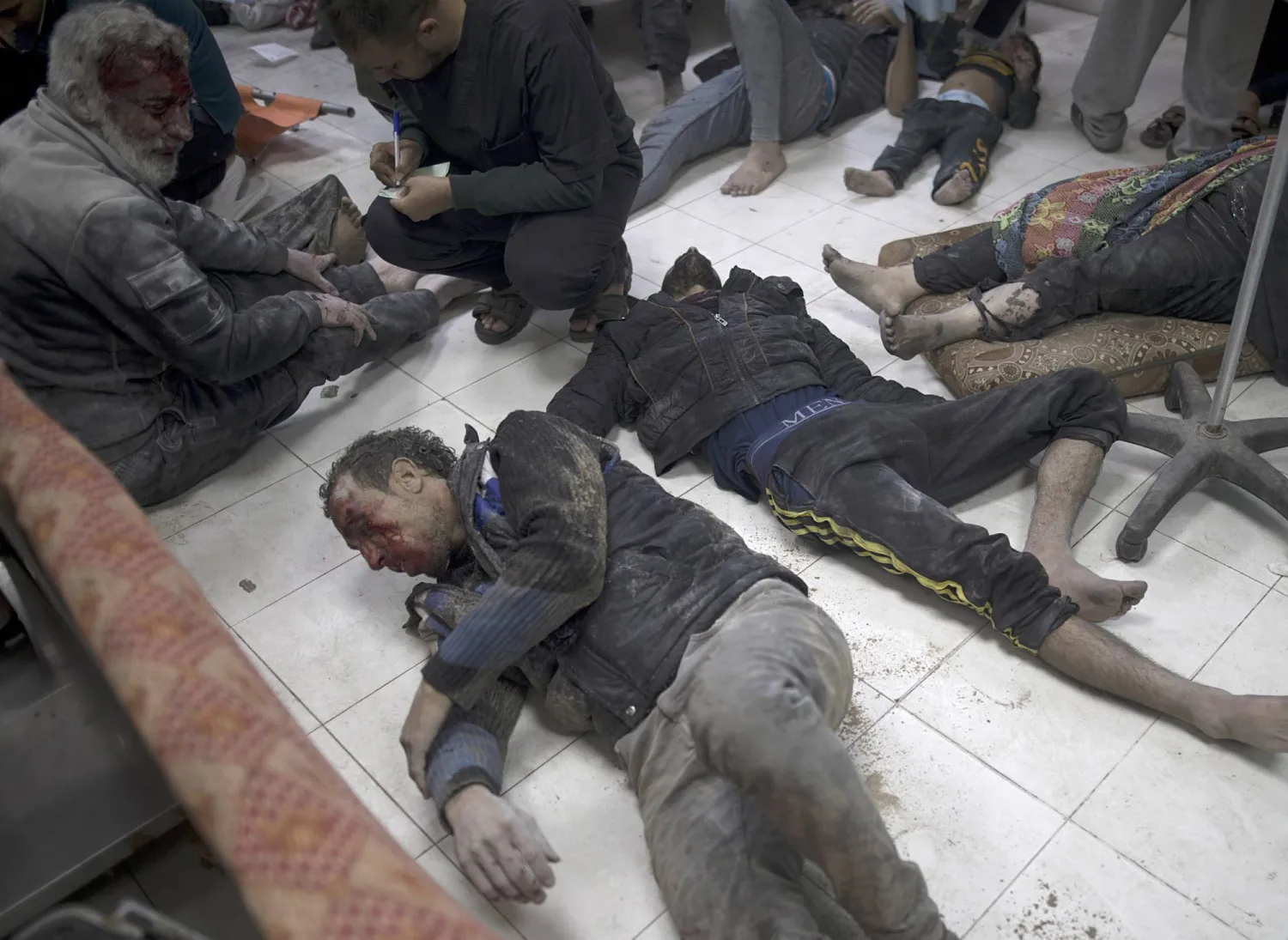 جرحى في غارات جوية إسرائيلية على جنوب غزة يرقدون على الأرض في مستشفى ناصر في خان يونس (إ.ب.أ)