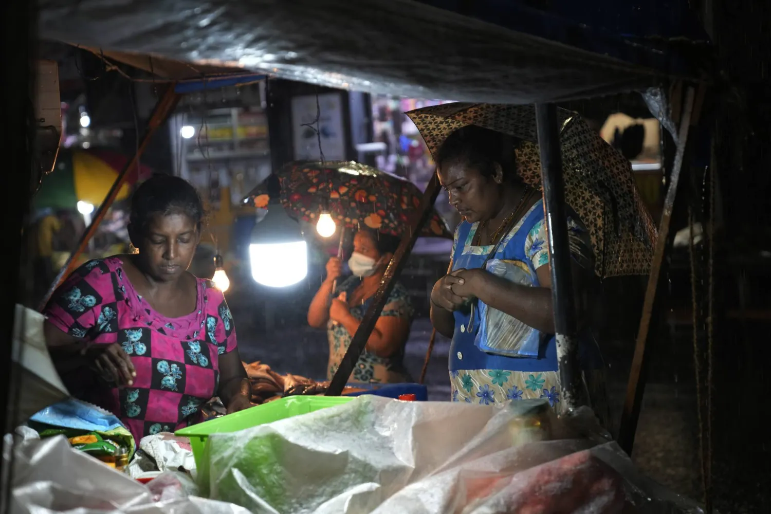 Women buy food from a roadside stall in Colombo, Sri Lanka, Friday, Dec. 8, 2023. (AP Photo/Eranga Jayawardena)