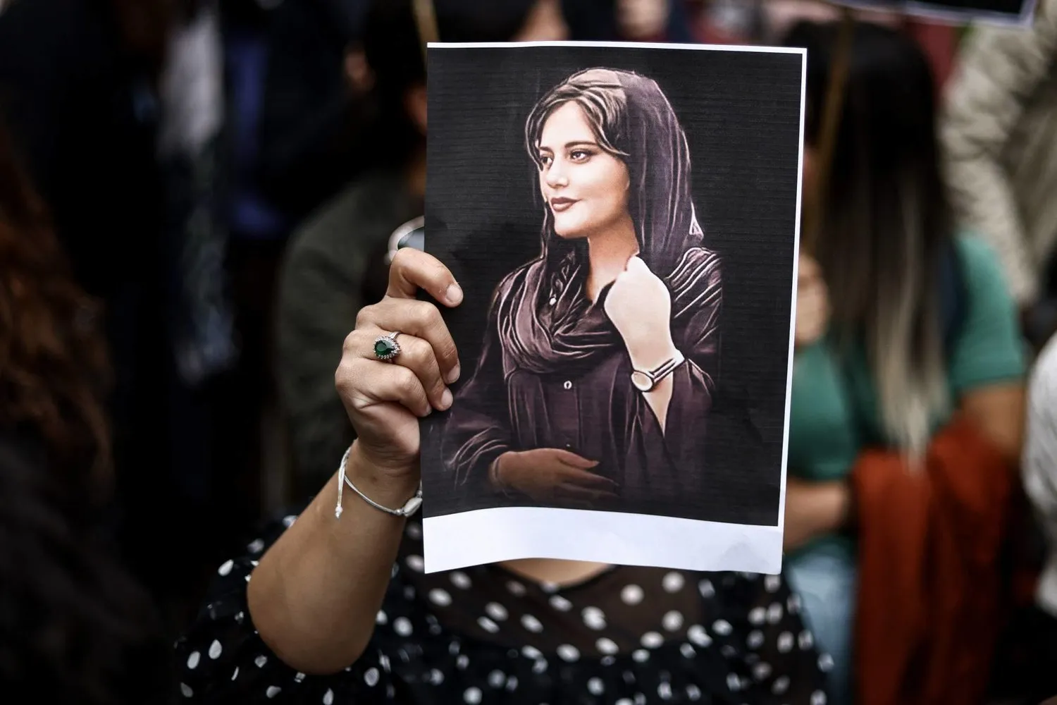  A protester holds a portrait of Mahsa Amini during a demonstration in front of the Iranian embassy in Brussels on Sept. 23, 2022 (AFP)
