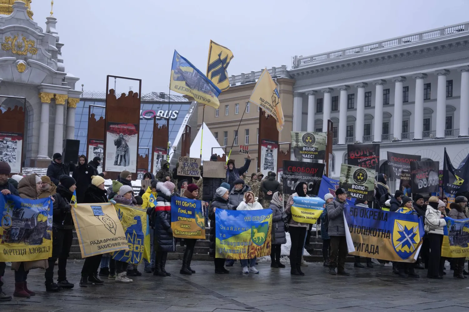 أقارب جنود أوكرانيين أسرتهم روسيا يحملون صورهم وملصقات تطالب بإطلاق سراحهم خلال تجمع وسط كييف الأحد (أ.ب)