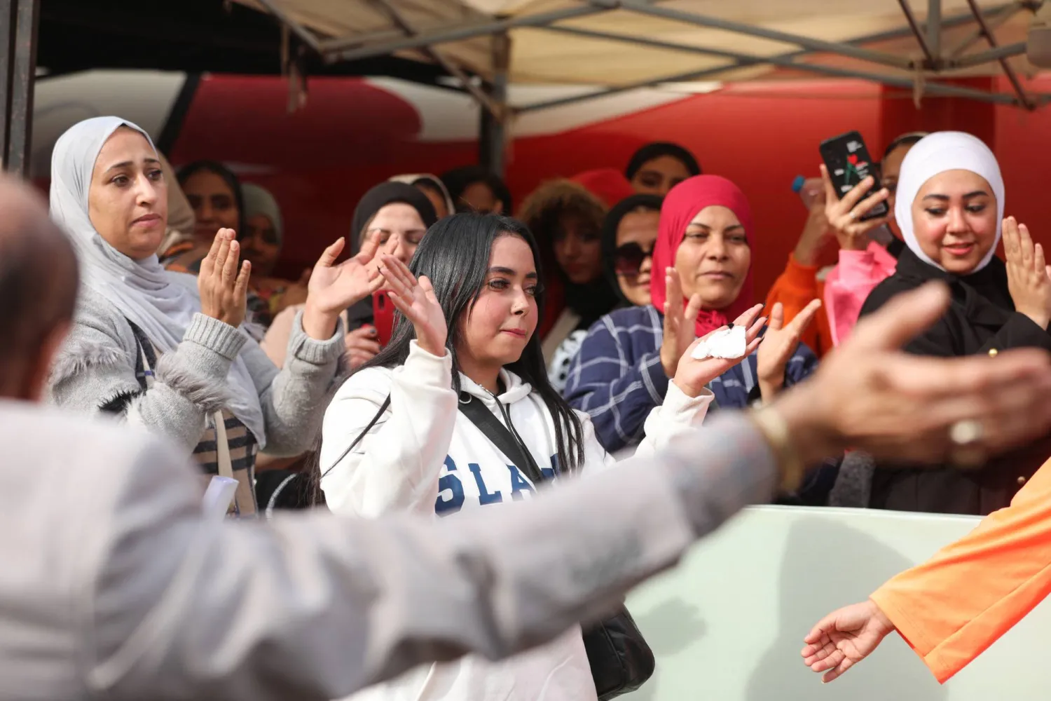 مصريات يغنين فرحاً أمام أحد المقار الانتخابية (رويترز)