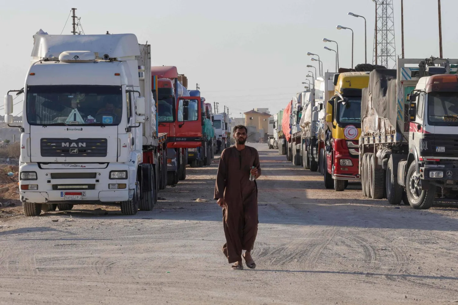 İnsani yardım yüklü tırlar, Mısır’ın Gazze sınırındaki Refah Sınır Kapısı’ndan girmek için bekliyor (AFP)
