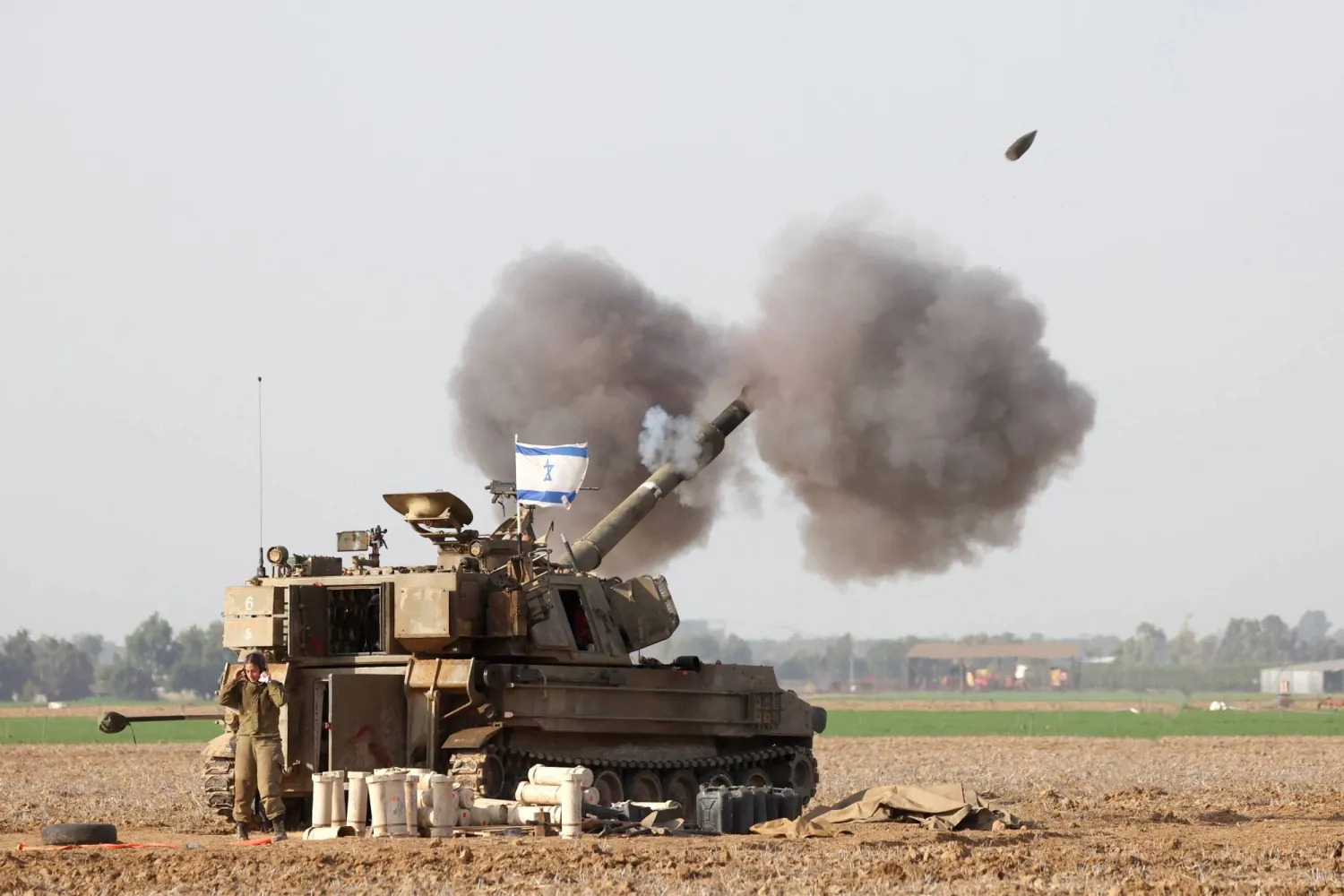 A picture taken in southern Israel near the border with the Gaza Strip on December 12, 2023, shows Israeli artillery firing towards Gaza, amid continuing battles between Israel and Hamas. (Photo by JACK GUEZ / AFP)
