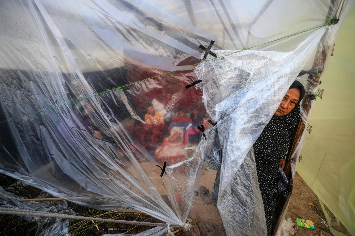 سيدة فلسطينية تنظر خارج خيمتها بعد النزوج من منزلها إلى مدينة رفح جنوب قطاع غزة (أ.ف.ب)