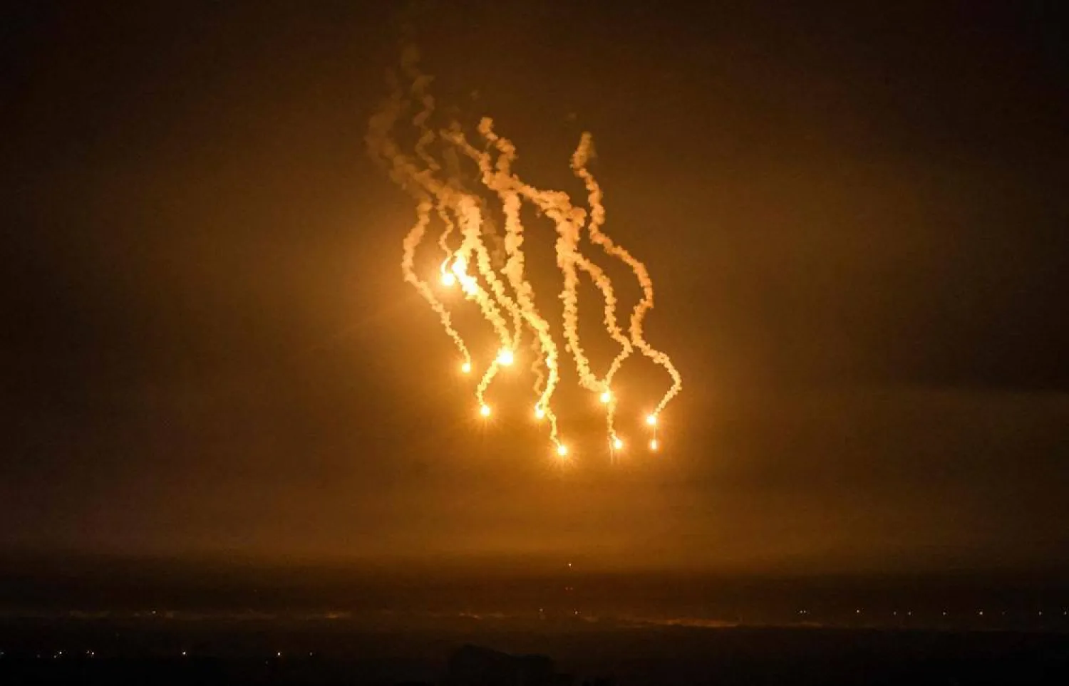 A picture taken from Rafah shows flares lighting the skies over Khan Yunis in the southern Gaza Strip during Israeli strikes, on December 14, 2023, amid continuing battles between Israel and the Palestinian militant group Hamas. (AFP)