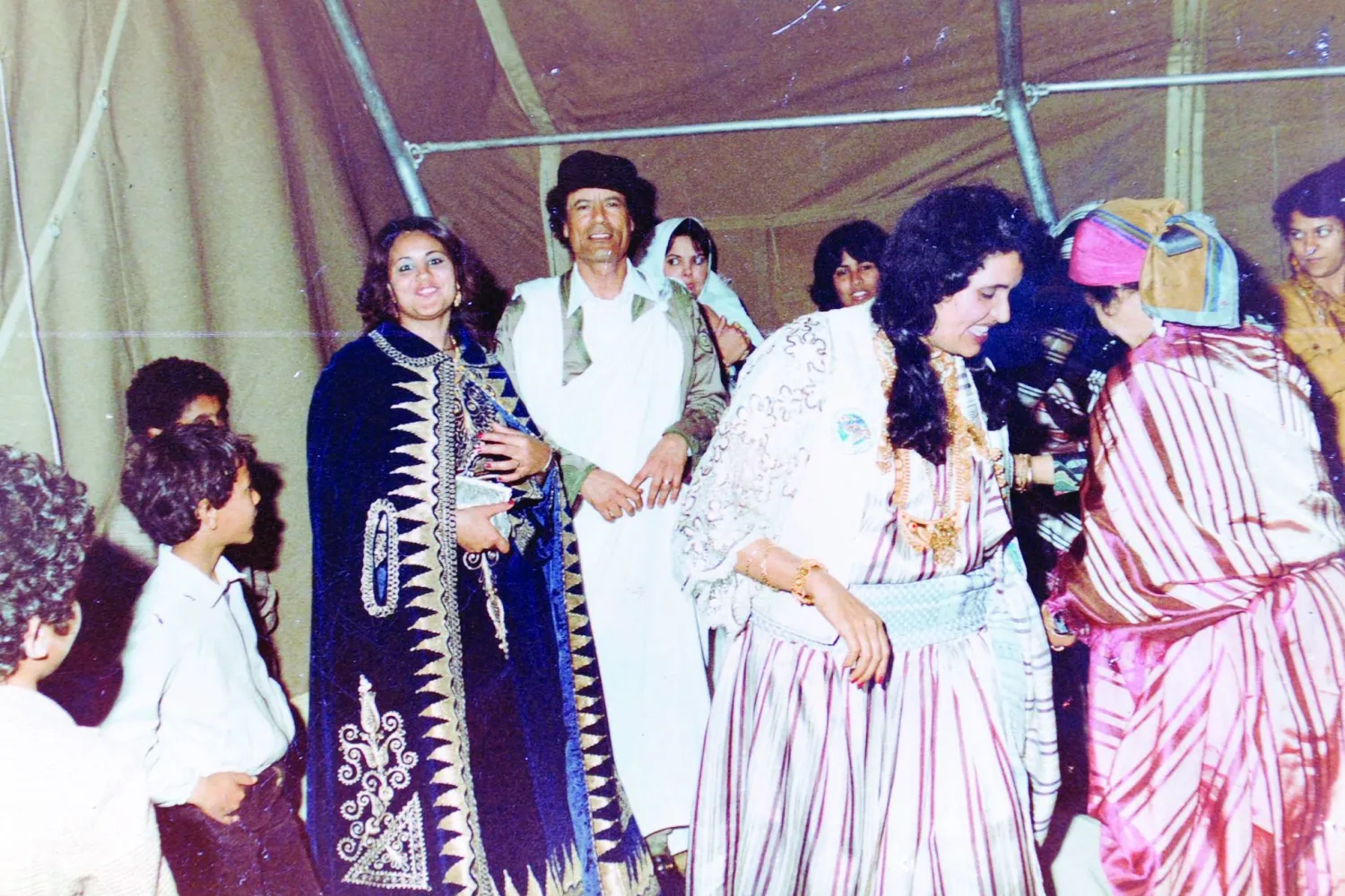  صورة أرشيفية للرئيس الراحل معمر القذافي وزوجته صفية خلال حفل زواج أحد أفراد العائلة (أ.ف.ب)