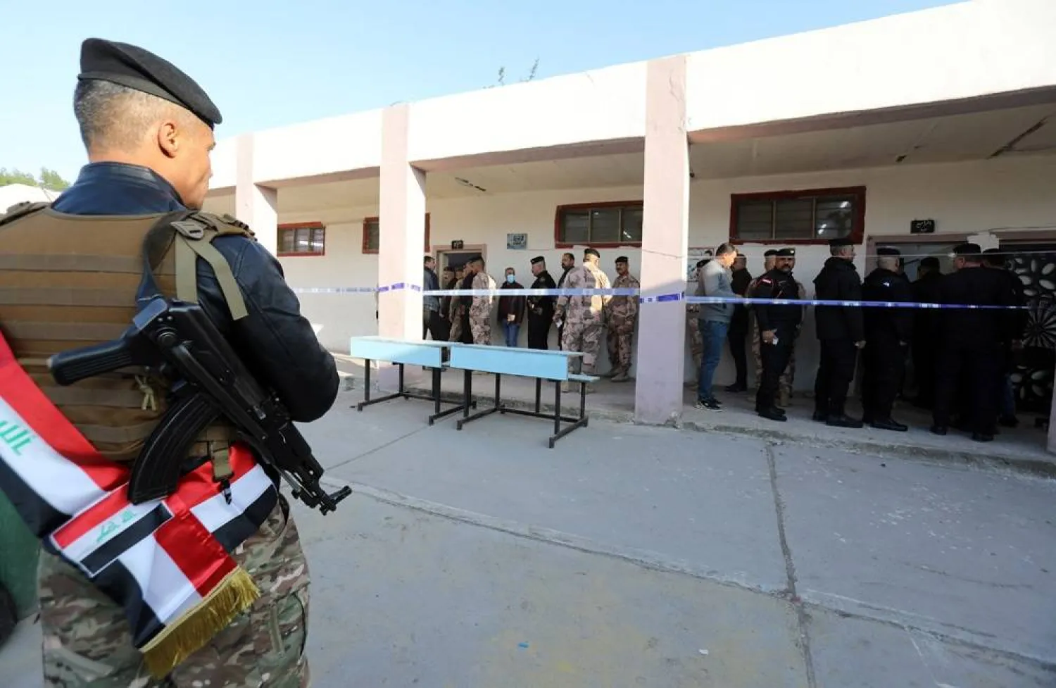 An Iraqi policeman stands guard as members of the Iraqi security forces arrive to vote during a special voting day for the provincial elections, at a poling station in Baghdad, Iraq, 16 December 2023. (EPA)