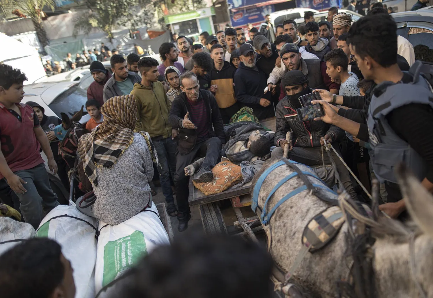 فلسطينيون ينقلون جثة إلى مستشفى ناصر في خان يونس على عربة يجرها حمار بعد غارة جوية إسرائيلية على جنوب غزة (إ.ب.أ)