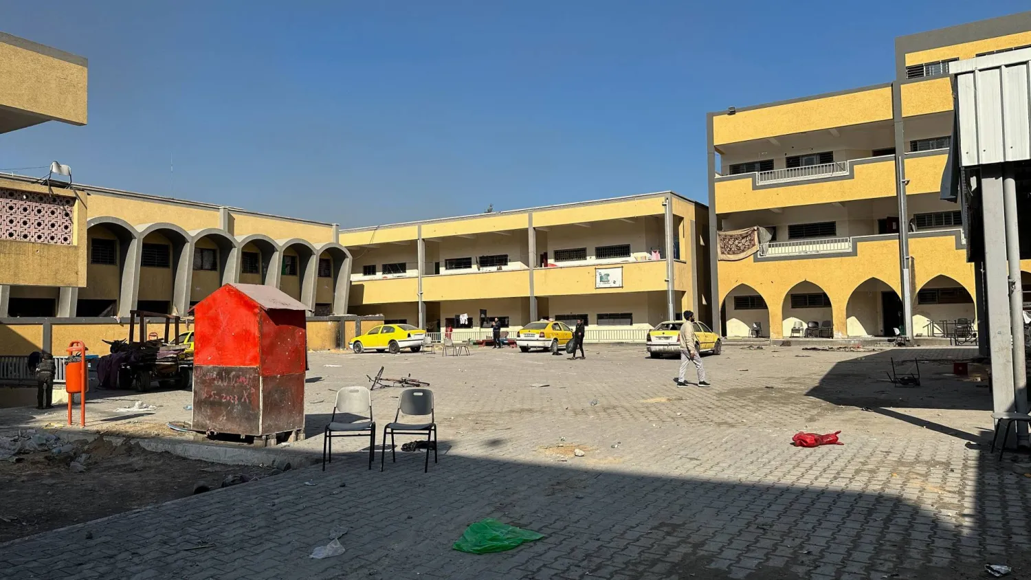 فلسطينيون يسيرون في مدرسة «شادية أبو غزالة» المتضررة في أعقاب غارة إسرائيلية في جباليا بشمال قطاع غزة (رويترز)