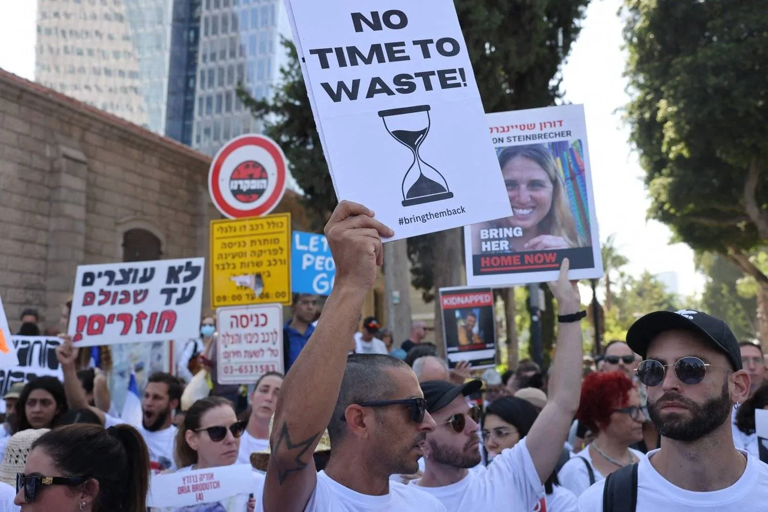 متظاهر يحمل لافتة تطالب بإطلاق سراح الأسرى في غزة خلال مظاهرة بتل أبيب (أ.ف.ب)