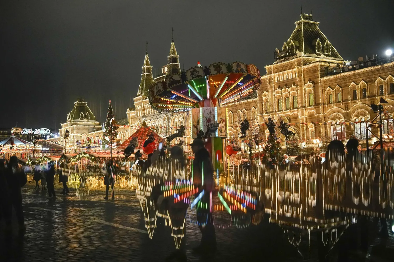 مشاة يعبرون في ساحة الميدان الأحمر وسط العاصمة الروسية موسكو التي تزينت لاستقبال العام الجديد وعيد الميلاد (أ.ب)