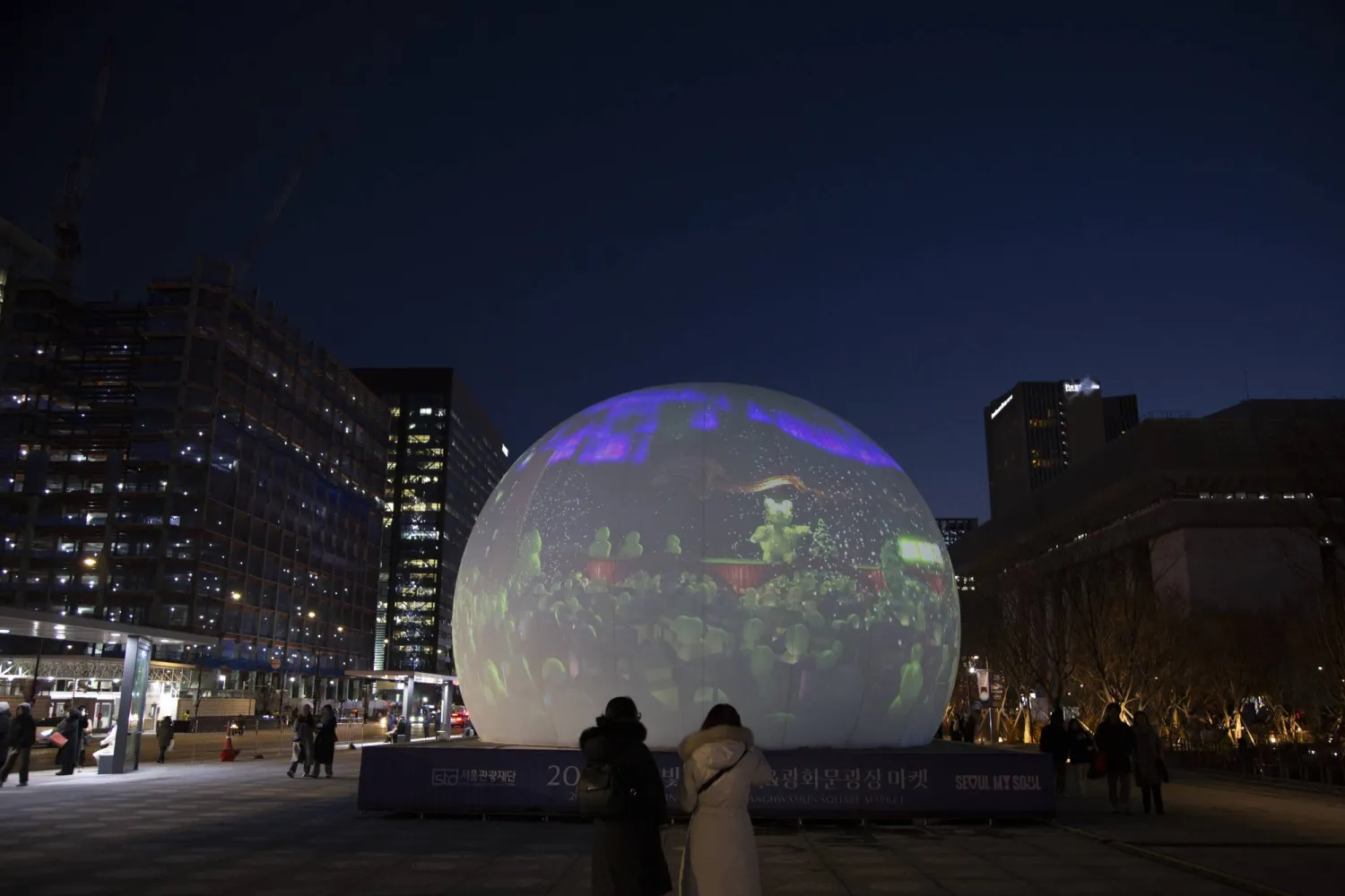 مشاة في أحد الشوارع المزدانة استعداداً للعام الجديد وسط العاصمة الكورية الجنوبية سيول (إ.ب.أ)