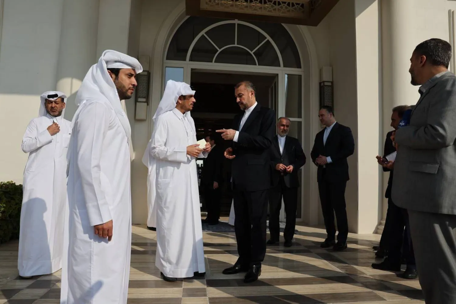 عبداللهيان يشير إلى ورقة بيد نظيره القطري في الدوحة اليوم (الخارجية الإيرانية)