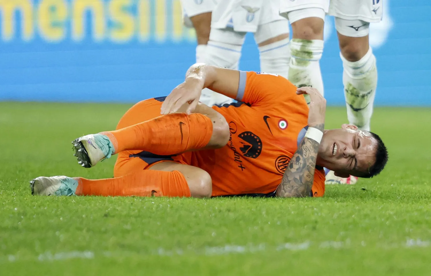 لاوتارو مارتينيز مهاجم إنتر ميلان متأثراً بإصابته خلال مواجهة لاتسيو في الدوري الإيطالي (رويترز)