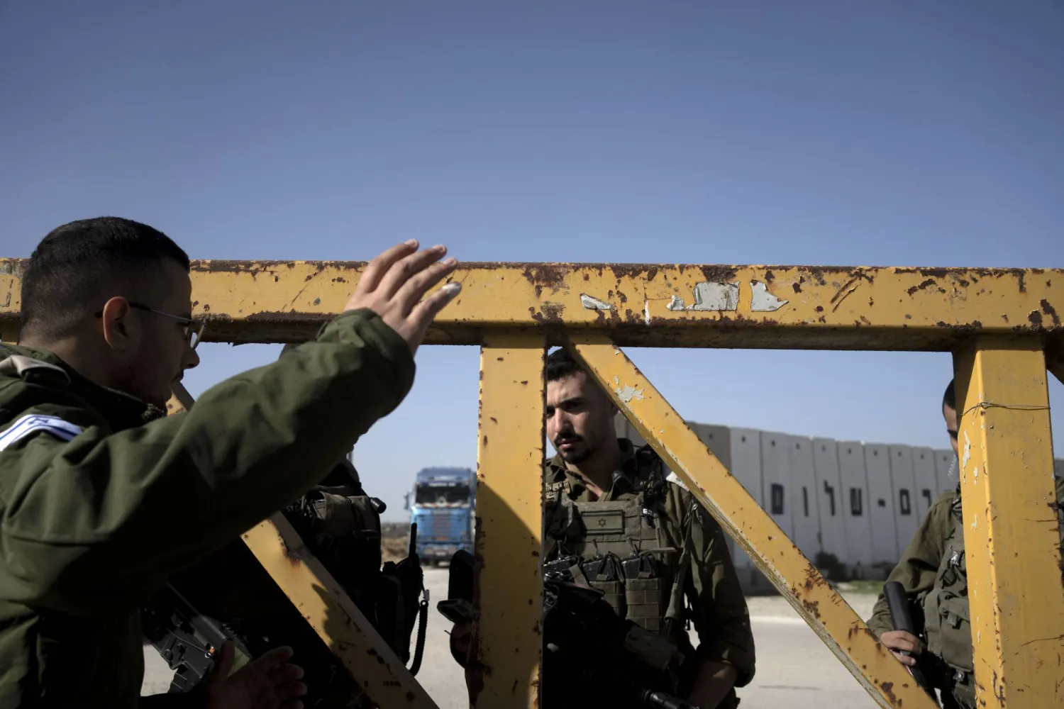 جنود إسرائيليون يعملون في معبر كرم أبو سالم بينما تنقل الشاحنات المساعدات الإنسانية من مصر إلى قطاع غزة (أ.ب)