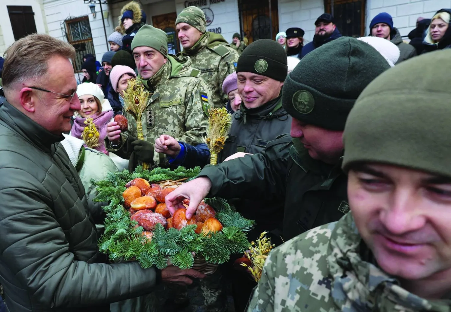 
جنود أوكرانيون يشاركون في احتفالات ليلة عيد الميلاد في لفيف أمس (رويترز)