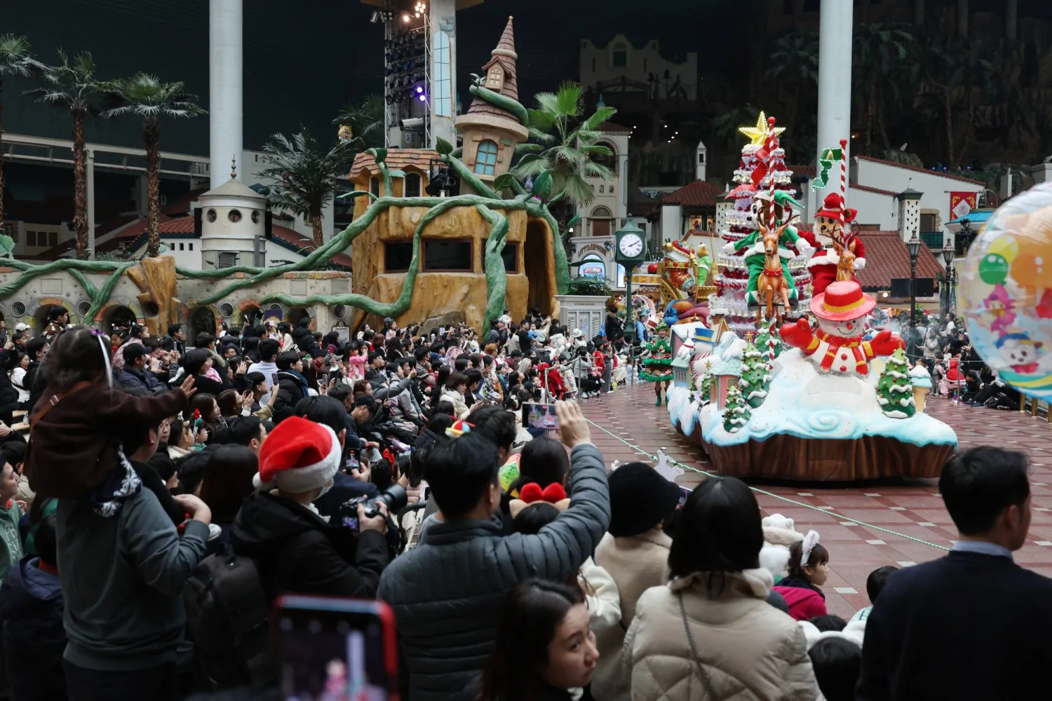 كوريون يحتشدون في أحد شوارع العاصمة سيول لمشاهدة عرض بمناسبة عيد الميلاد (إ.ب.أ)