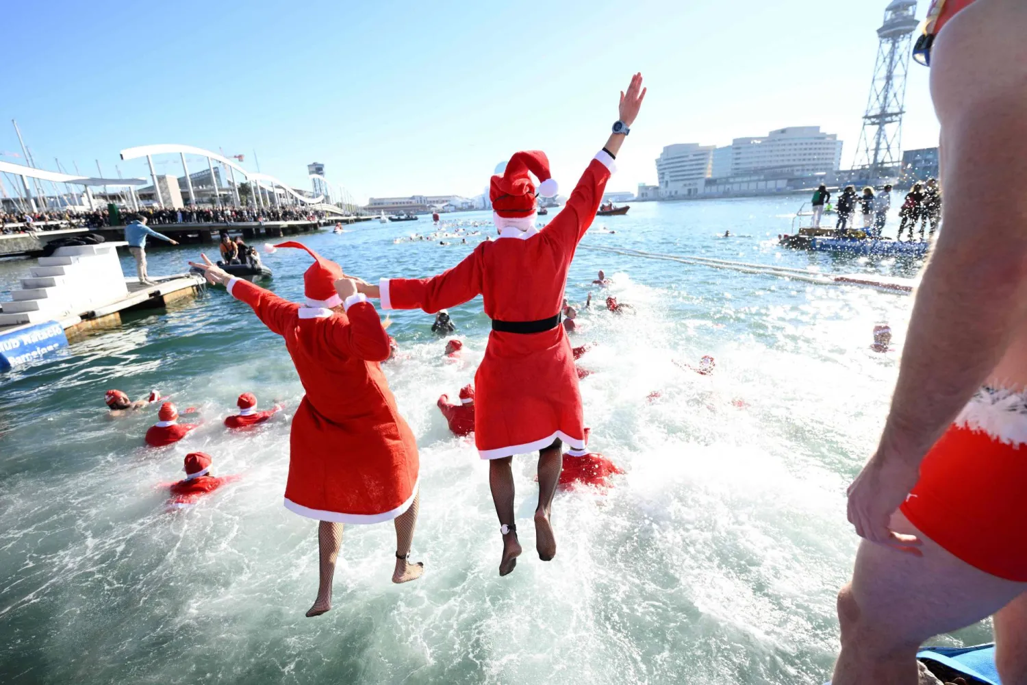 المشاركون في زي سانتا كلوز يقفزون في الماء ببرشلونة (أ.ف.ب)