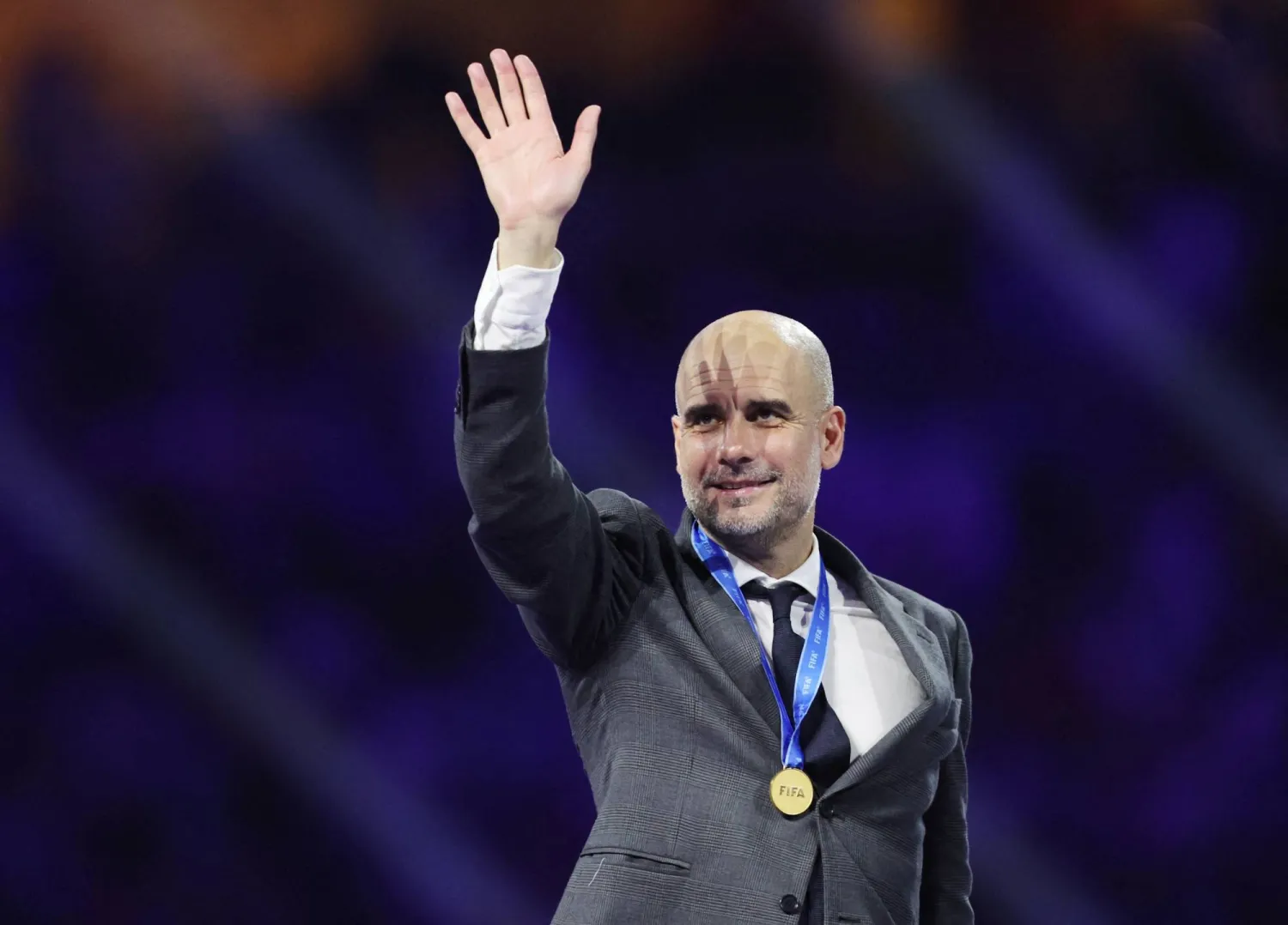 غوارديولا متقلداً الميدالية الذهبية خلال مراسم تتويج مانشستر سيتي ببطولة كأس العالم للأندية في جدة (رويترز)