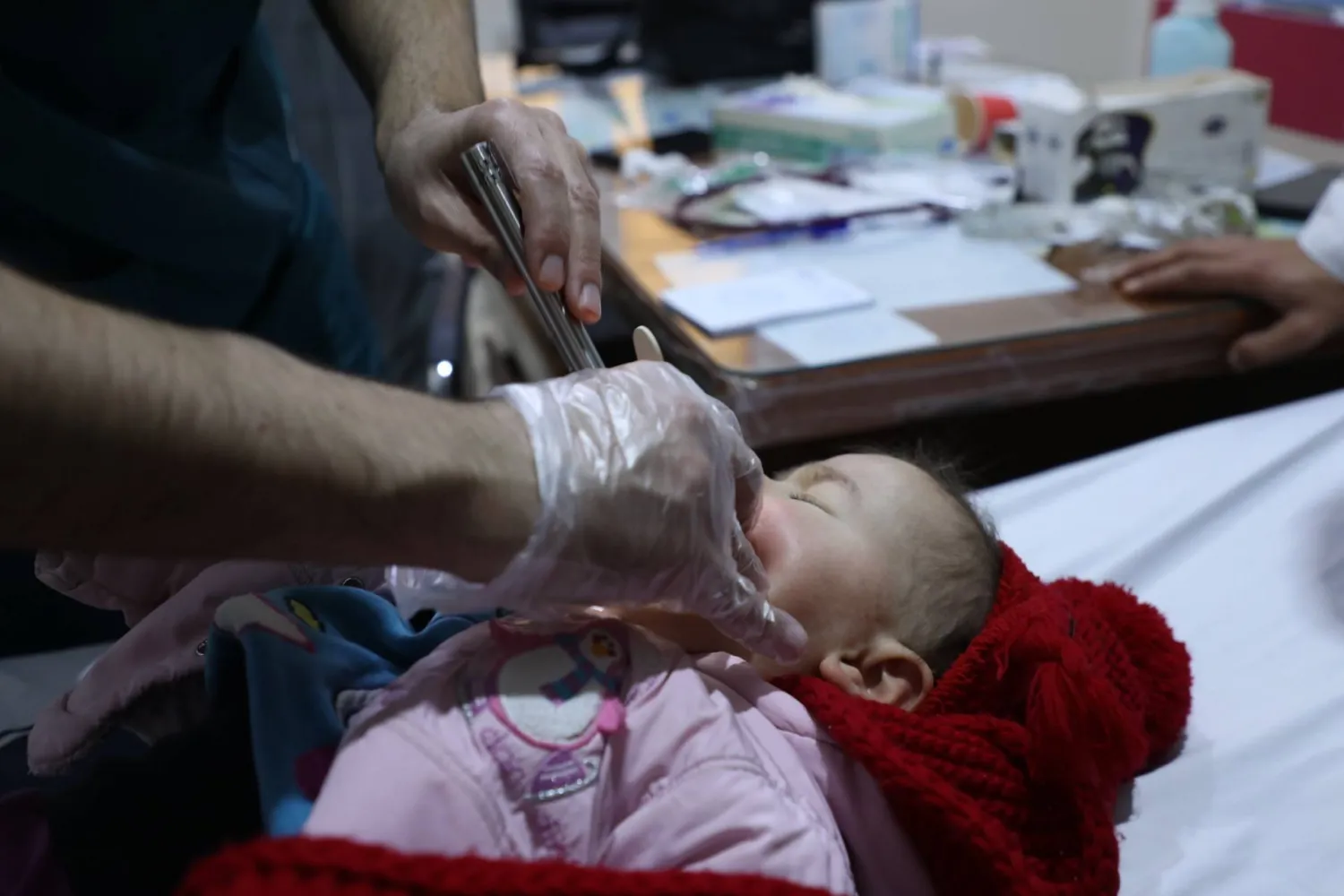 طفل مصاب بالاختناق يعاينه الطبيب في مشفى «ابن سينا» في إدلب (الشرق الأوسط)