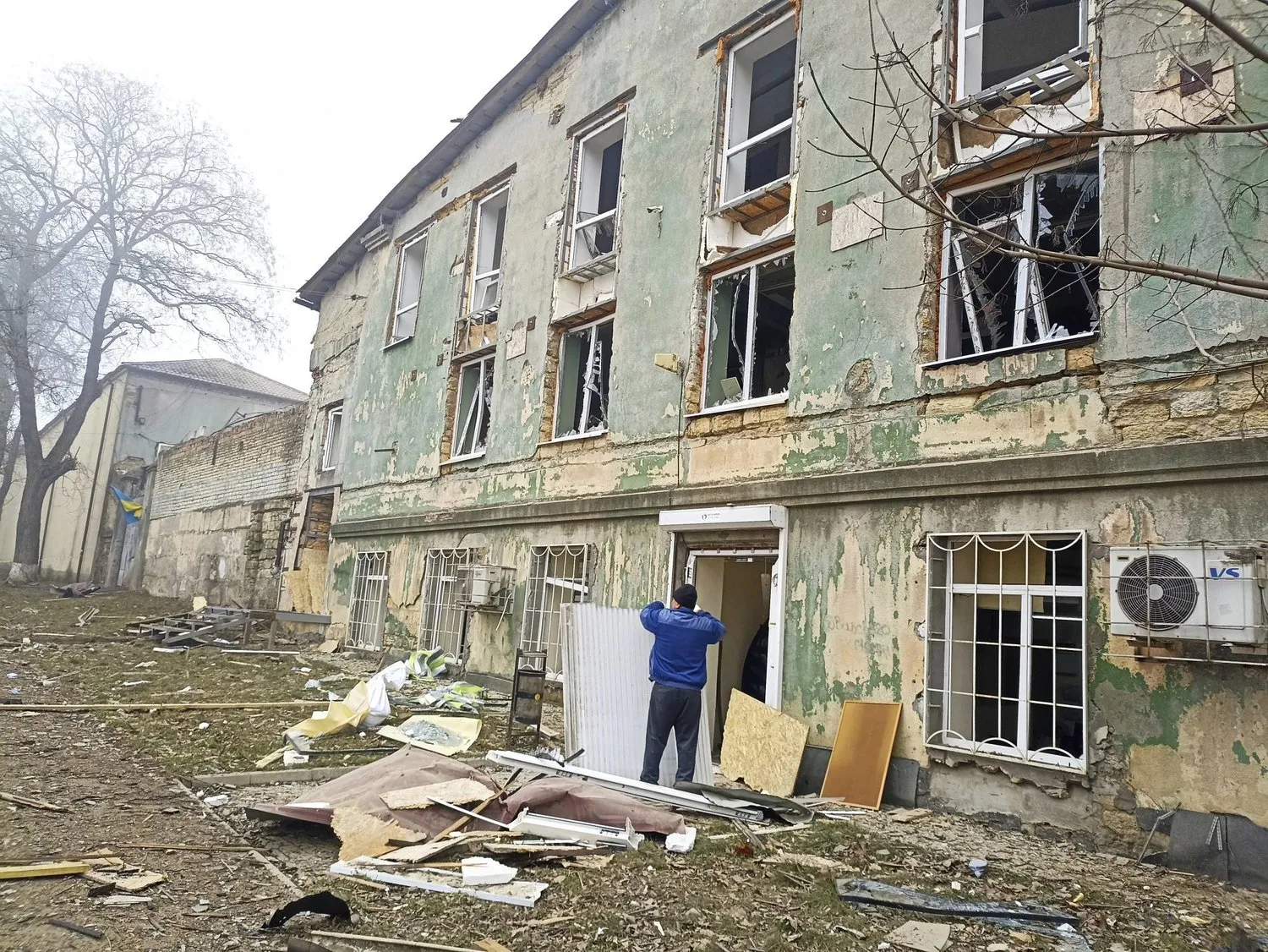 Bugün Ukrayna’nın Odessa kentine yönelik Rus saldırısından sonra hasar gören bir binanın yanında bir adam duruyor (AP)