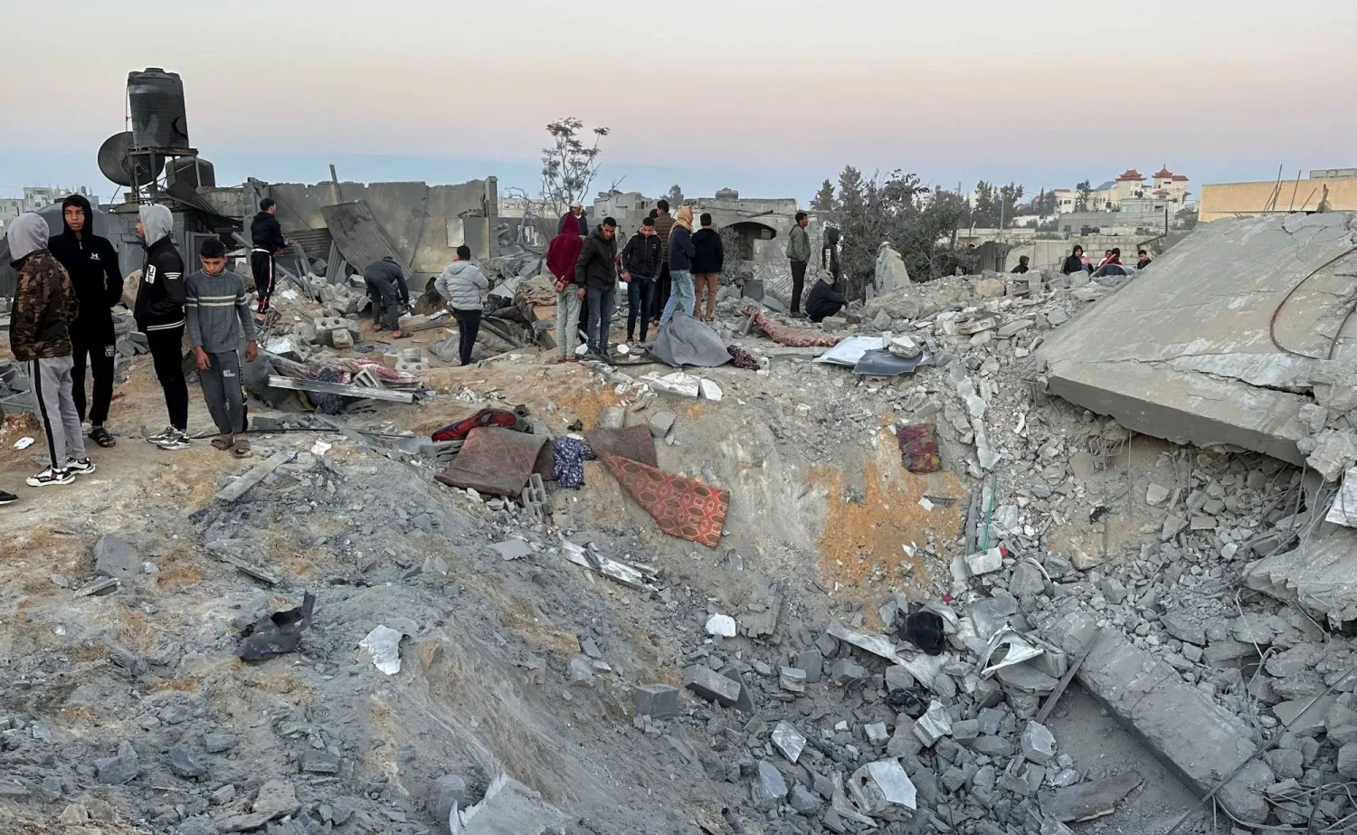 فلسطينيون يتجمعون في موقع تعرض لغارة إسرائيلية وسط الصراع المستمر بين إسرائيل وحركة «حماس» في رفح بجنوب قطاع غزة في 29 ديسمبر 2023 (رويترز)