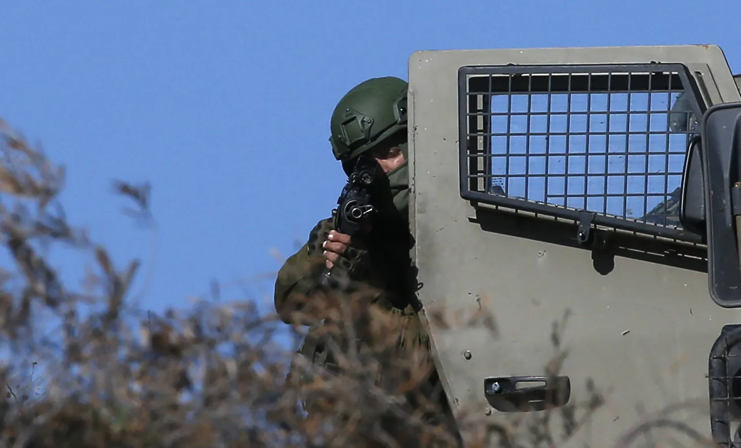 جندي إسرائيلي مشهراً سلاحه خلال اقتحام القوات الإسرائيلية لمخيم الفارعة في الضفة الغربية (إ.ب.أ)