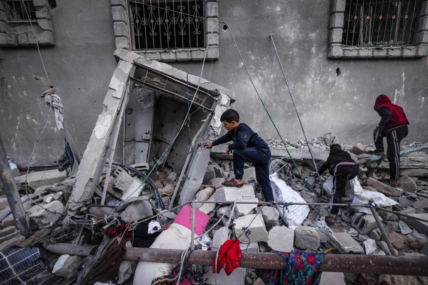 أطفال يتفقدون أنقاض مبنى دمّره قصف إسرائيلي على رفح جنوب قطاع غزة (أ.ف.ب)