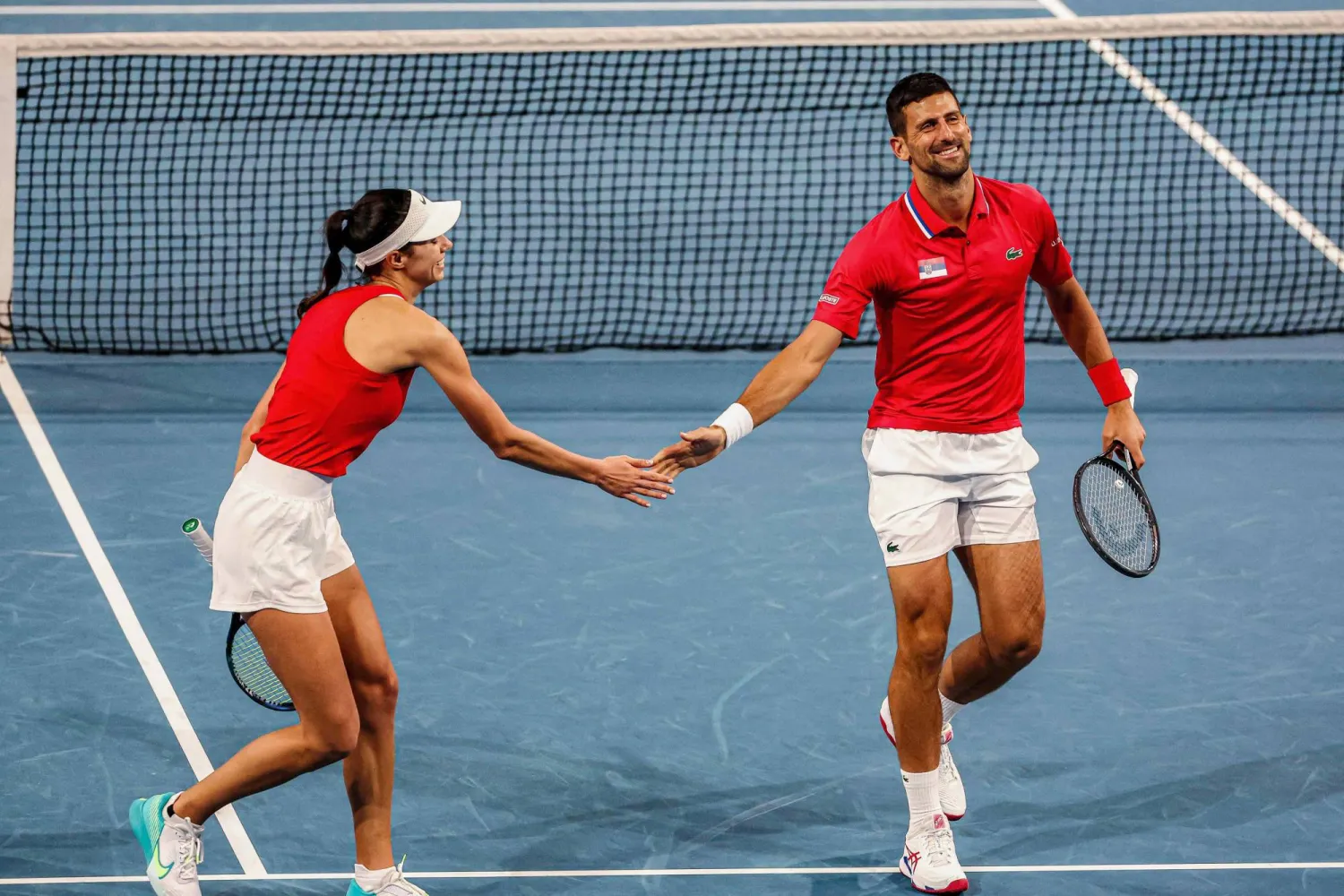 الصربيان نوفاك ديوكوفيتش وأولغا دانيلوفيتش يحيي كل منهما الآخر عقب الفوز على الصين ضمن منافسات «كأس يوناتيد للتنس»... (أ.ف.ب)