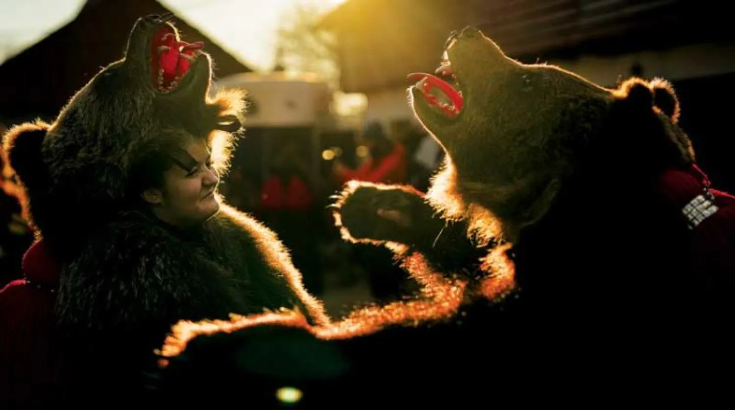 استعراض للأشخاص الذين يرتدون أزياء من فرو الدب في رومانيا (أ.ب)